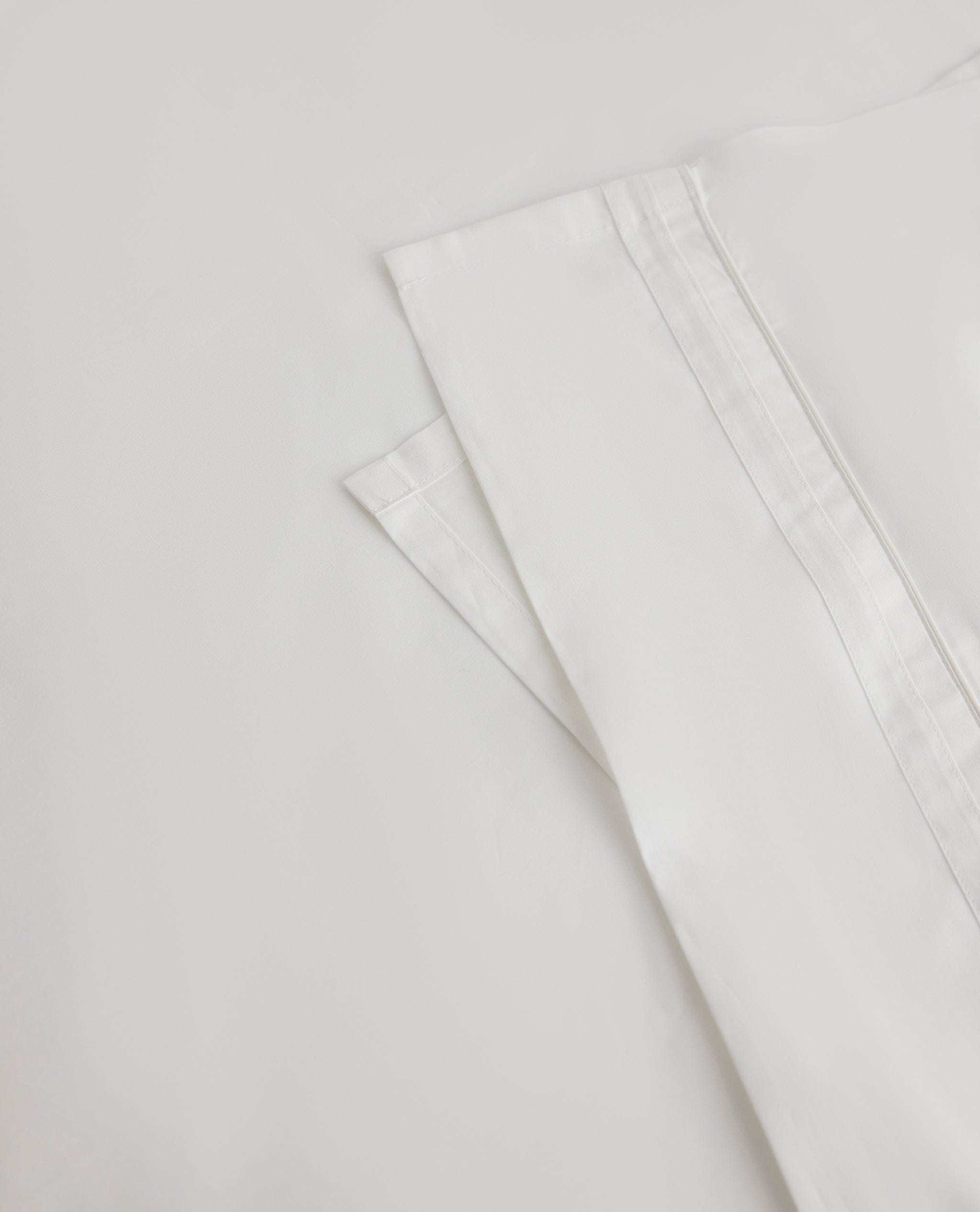Image 2 of 5 showing Rise & Fall's Crisp & Cool organic percale cotton flat bed sheet in white tailored border.