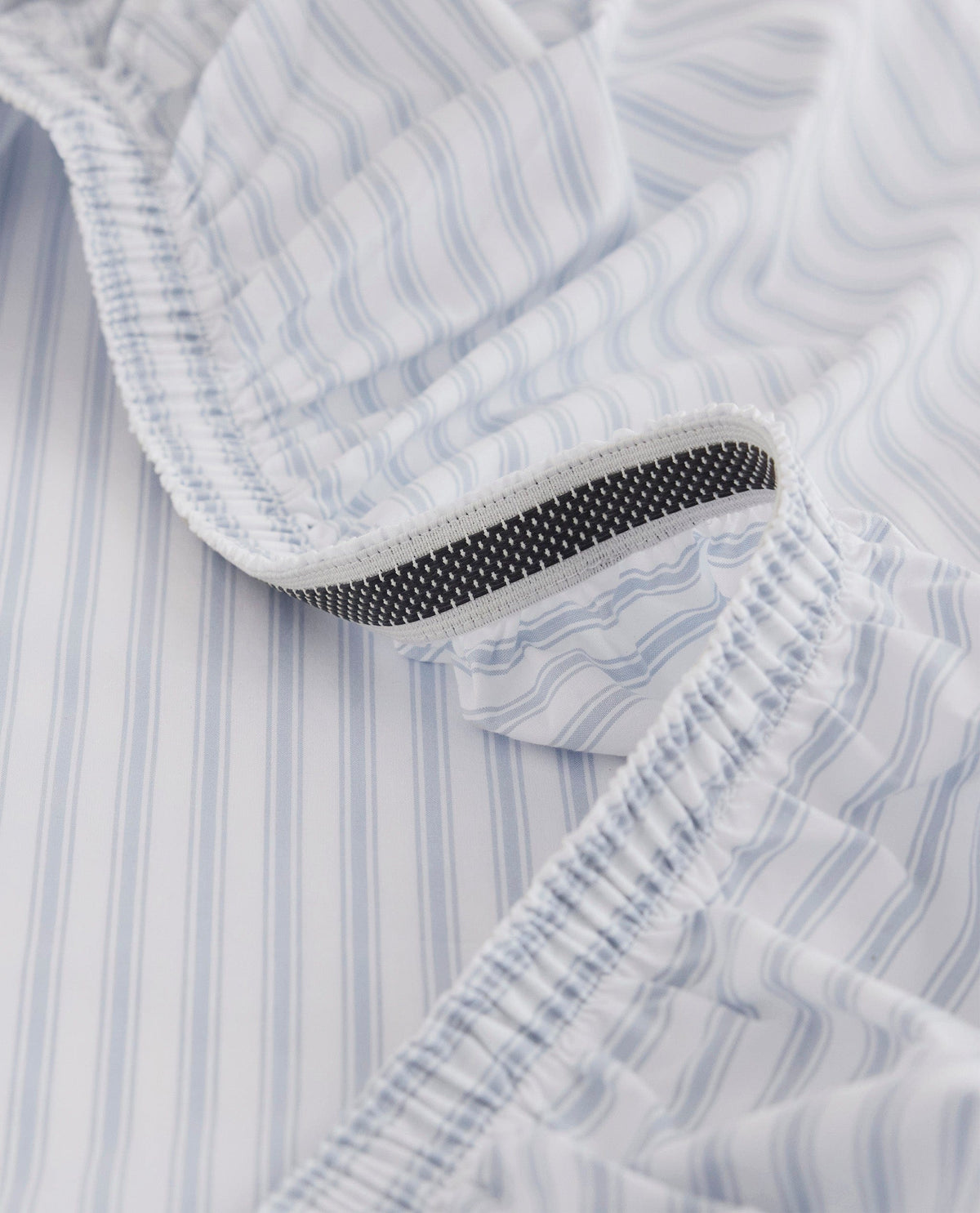 Image 2 of 6 showing Rise & Fall's Crisp & Cool organic cotton fitted bed sheet in blue stripe ticking.