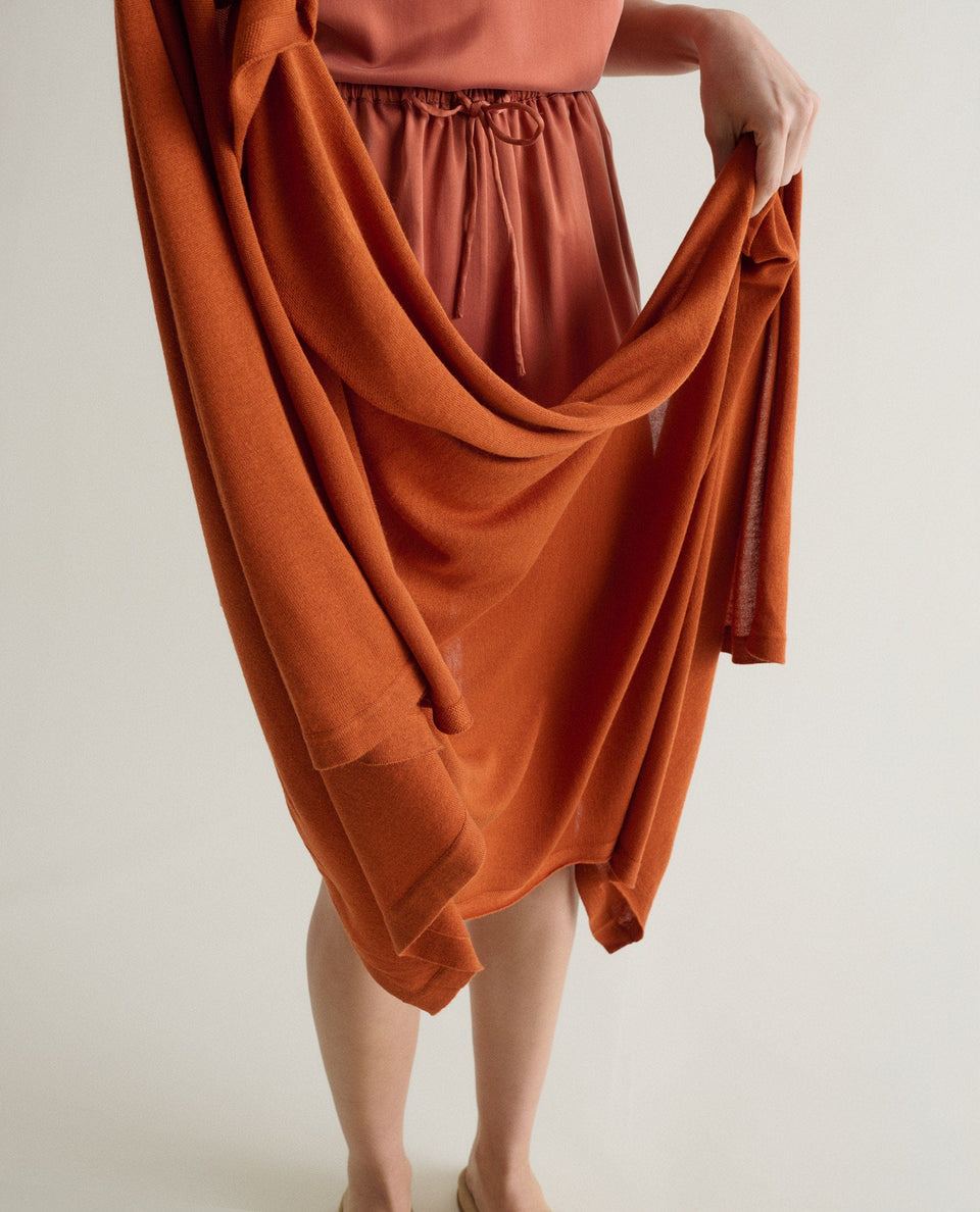 Image 2 of 6 showing woman with Rise & Fall's oversized cashmere scarf in rust.