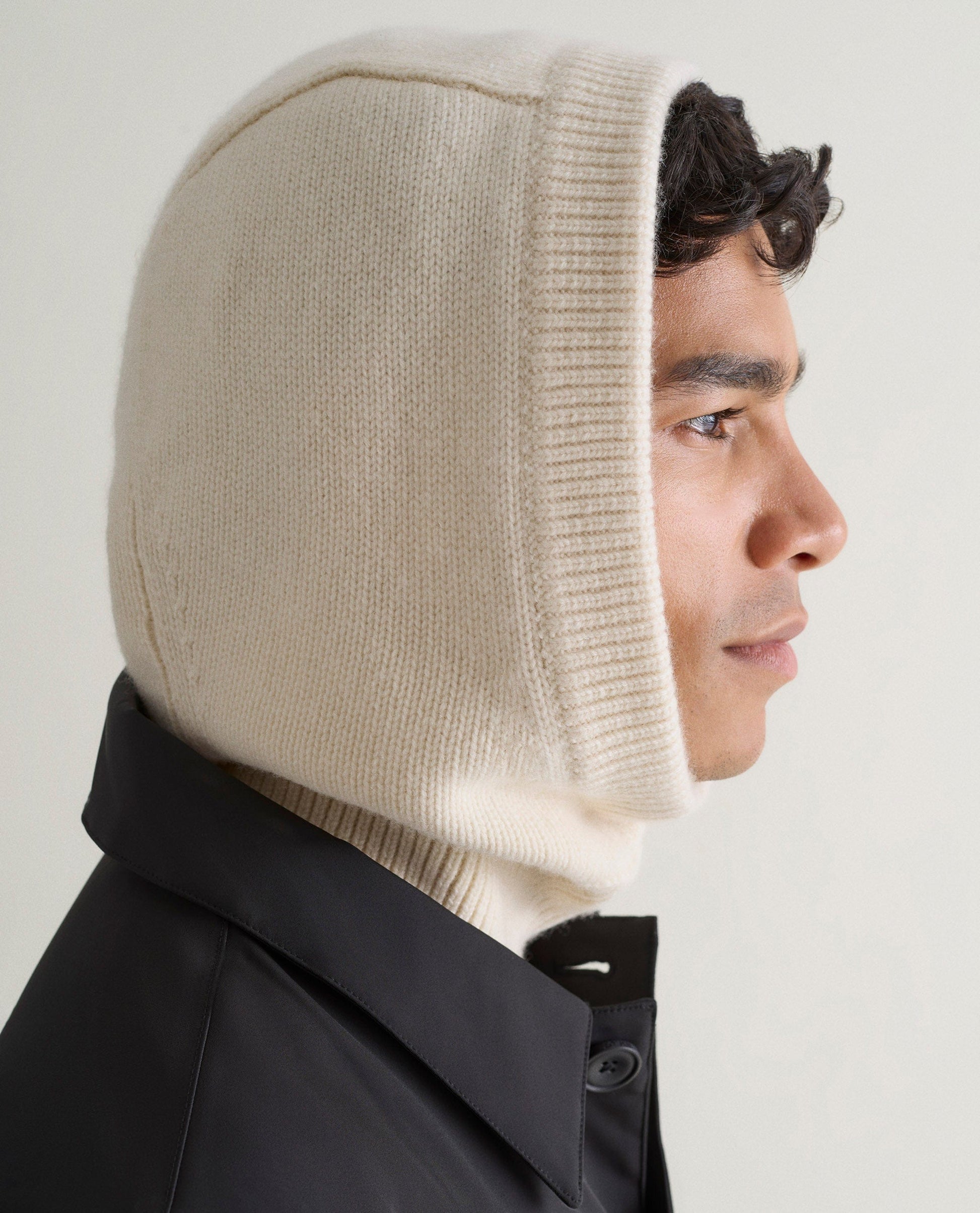 Image 3 of 3 showing side view of man wearing Rise & Fall's cream Cashmere Merino Knitted Hood.