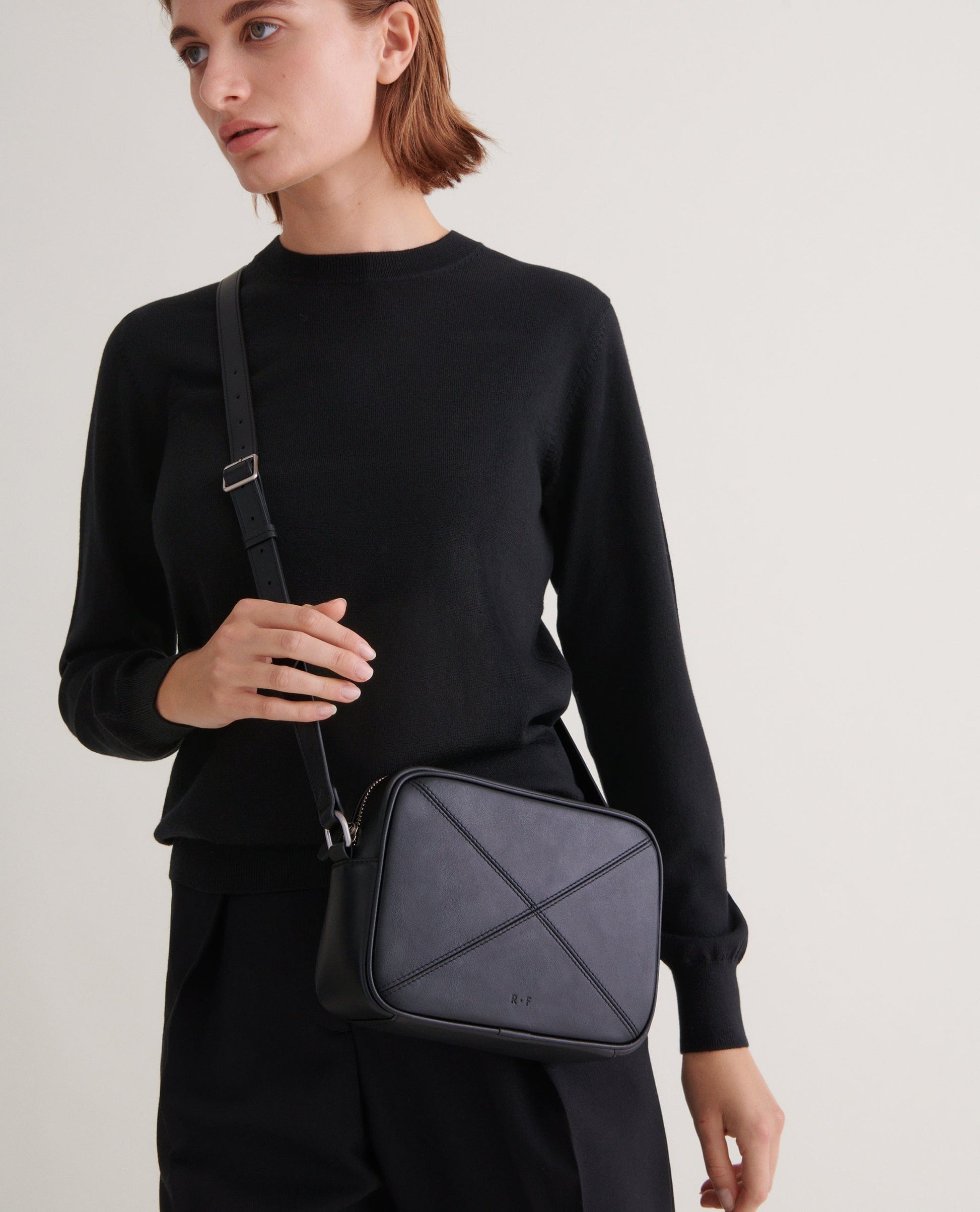 Image 3 of 3 showing woman wearing Rise & Fall's Finest Cashmere Classic Crew Neck Jumper in black.