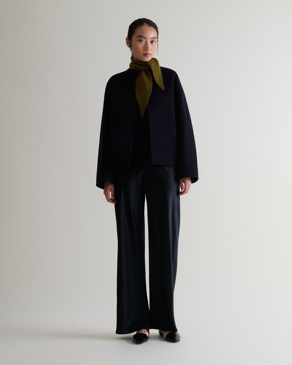 Image 3 of 3 showing Rise & Fall's finest cashmere ribbed micro bandana in olive with black trousers and jacket.