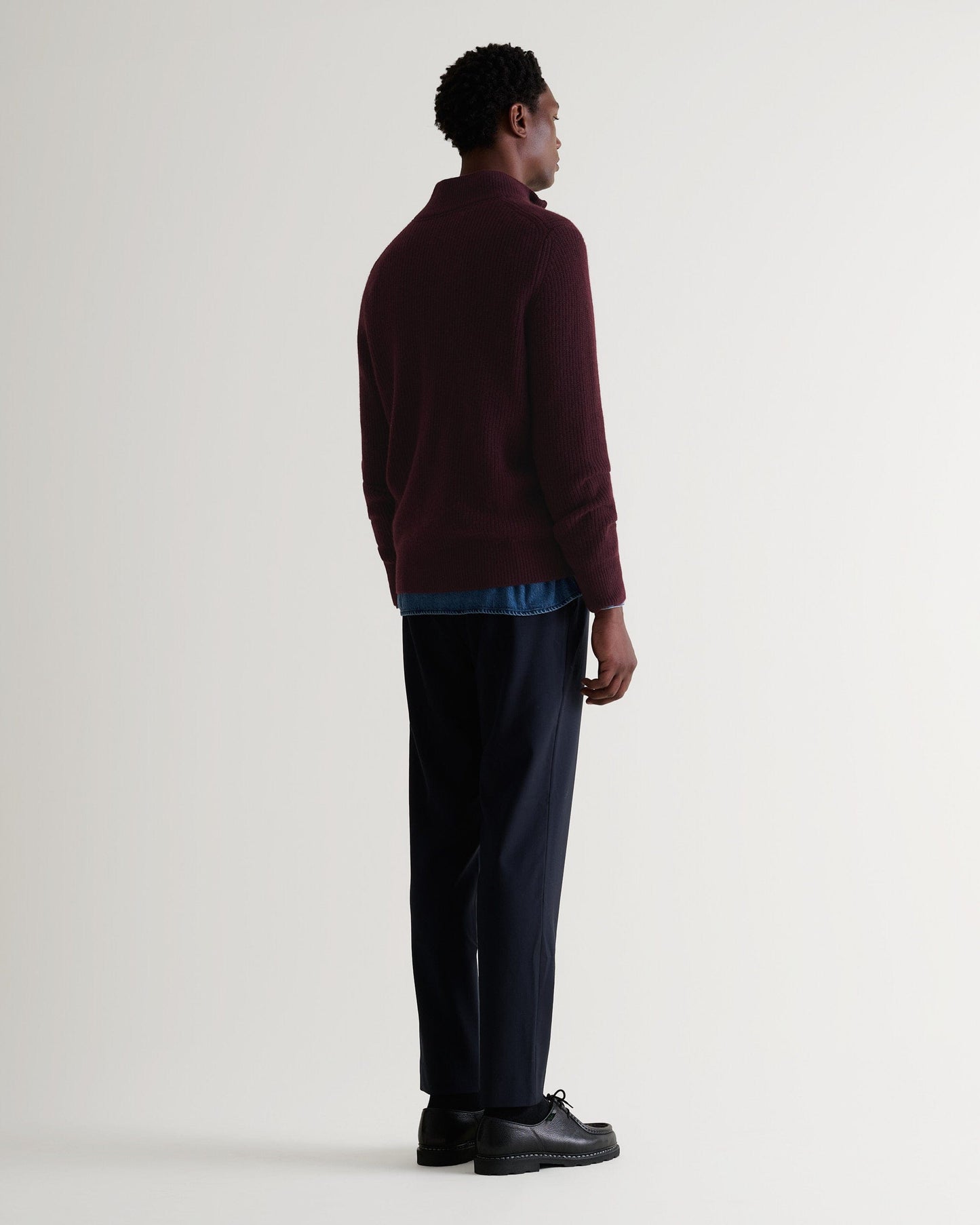 Image 3 of 4 showing back of man wearing Rise & Fall's Cashmere Merino Fishermans Rib 1/4 Zip Jumper in oxblood.