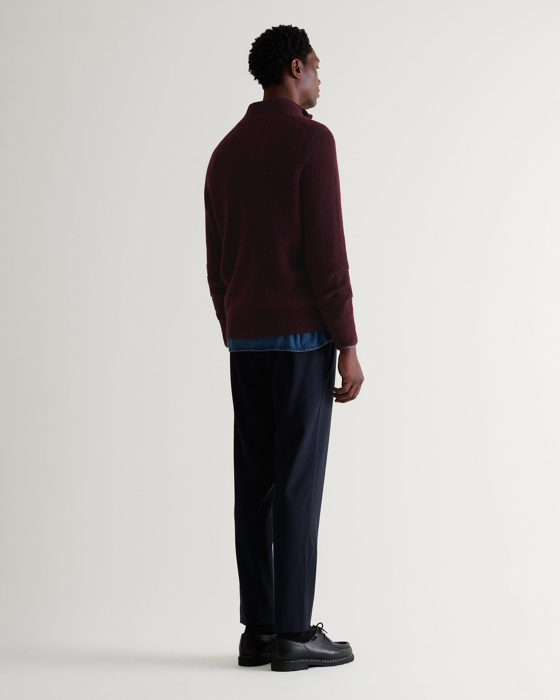 Image 3 of 4 showing back of man wearing Rise & Fall's Cashmere Merino Fishermans Rib 1/4 Zip Jumper in oxblood.