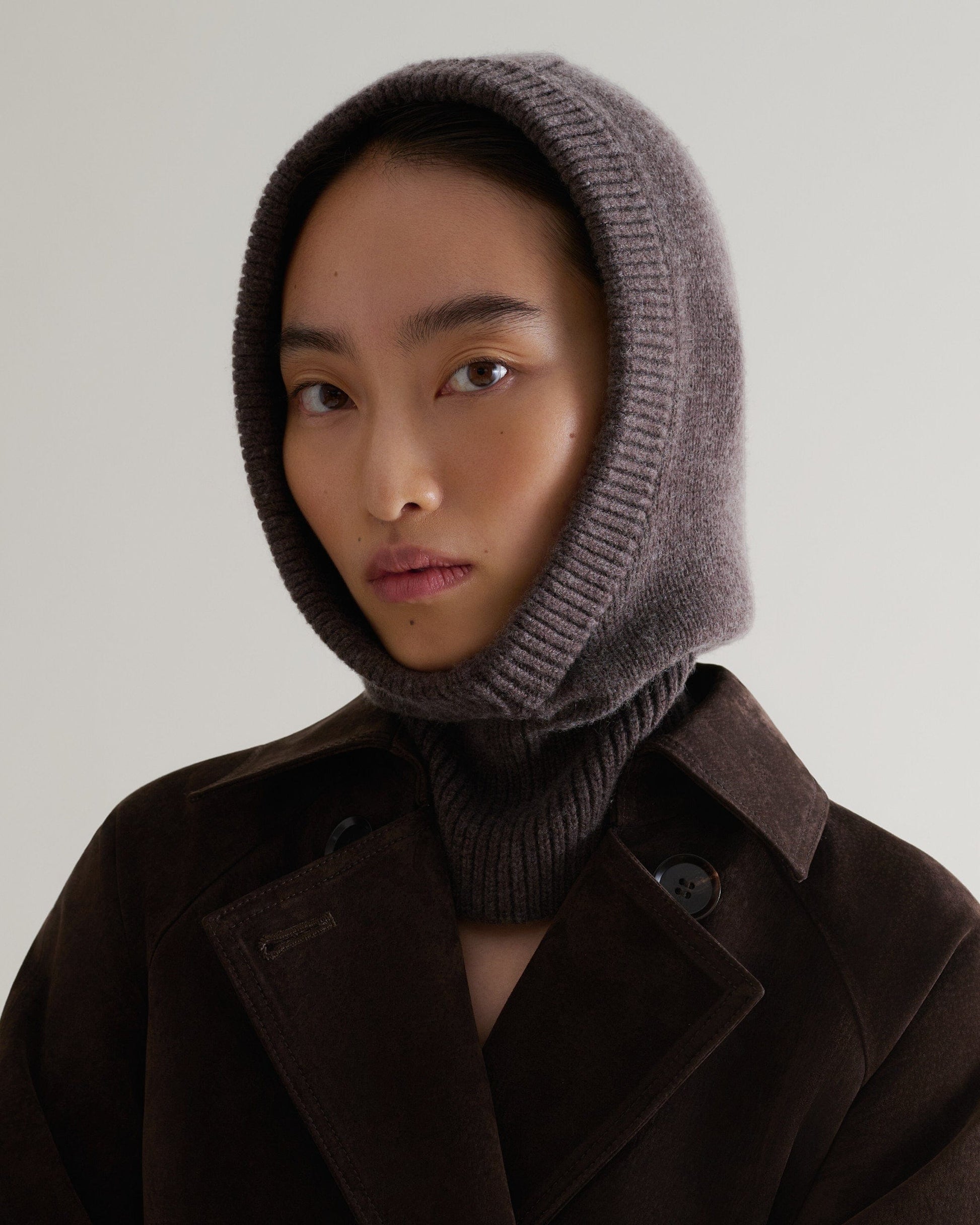 Image 3 of 4 showing woman wearing Rise & Fall's chocolate brown Cashmere Merino Knitted Hood.