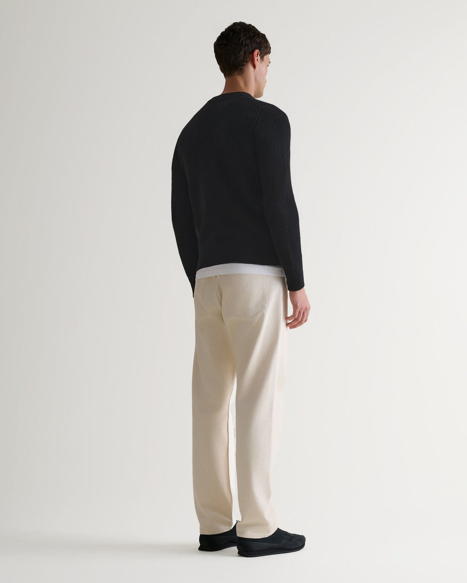 Image 3 of 5 showing back of man wearing Rise & Fall's Cashmere Merino Fishermans Rib Crew Neck Jumper in black.