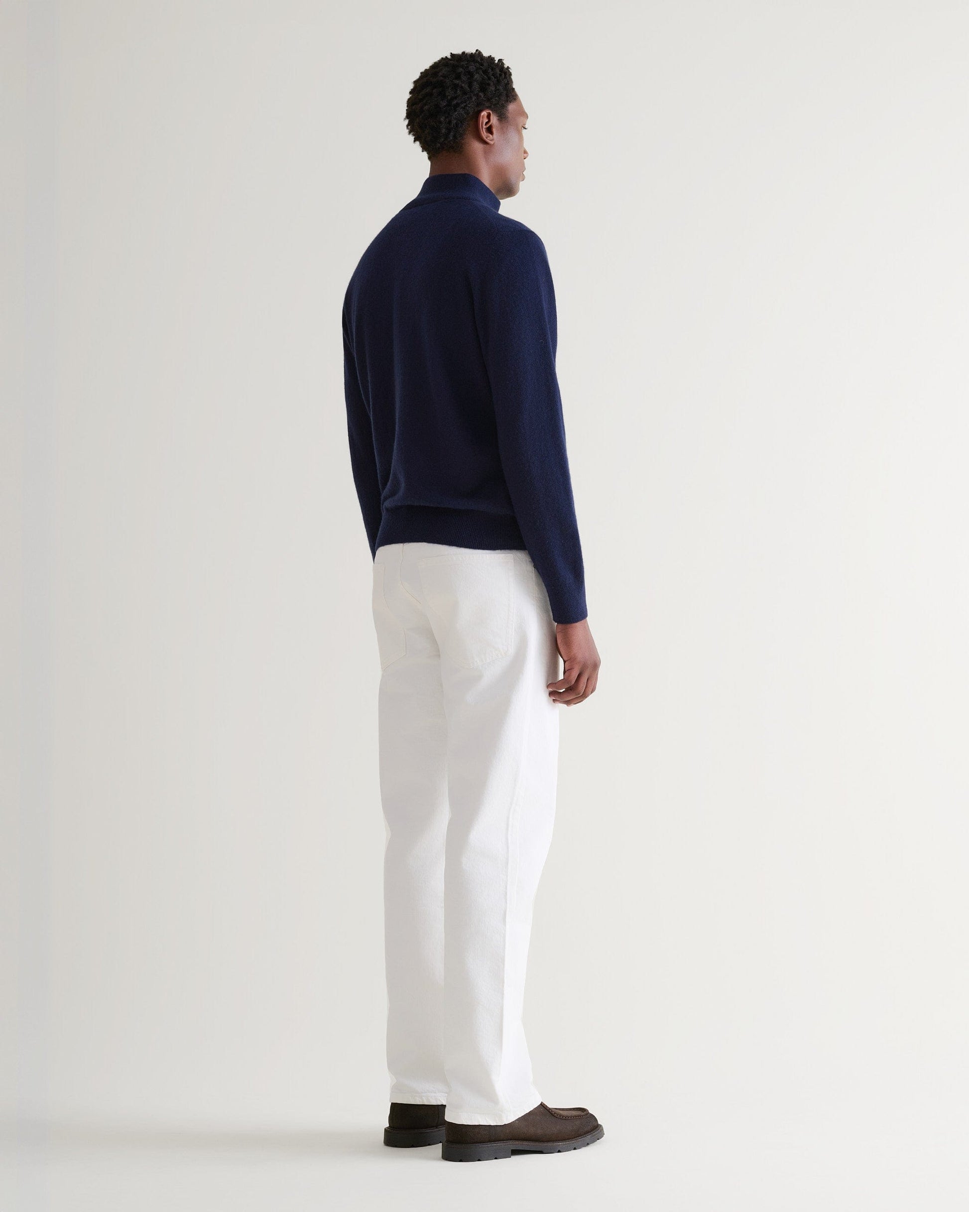 Image 3 of 5 showing man wearing Rise & Fall's fine cashmere 1/4 zip jumper, navy, back view.