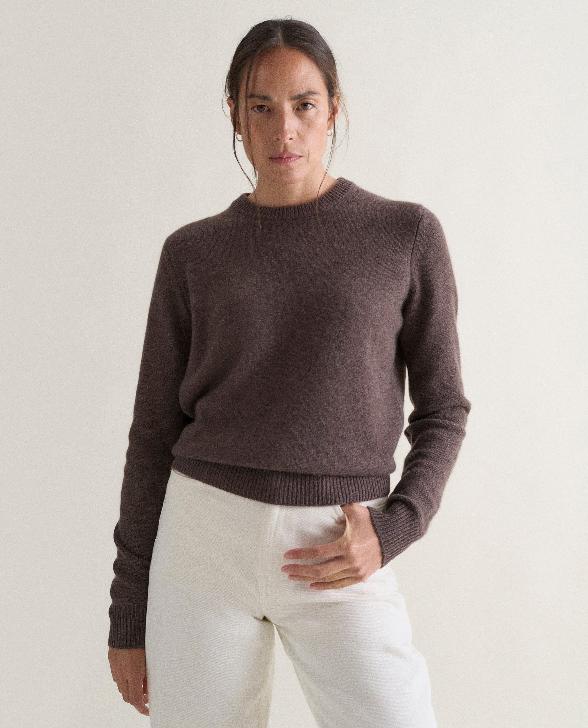 Image 3 of 5 showing woman wearing Rise & Fall's brown mid-weight cashmere crew neck jumper with white jeans.