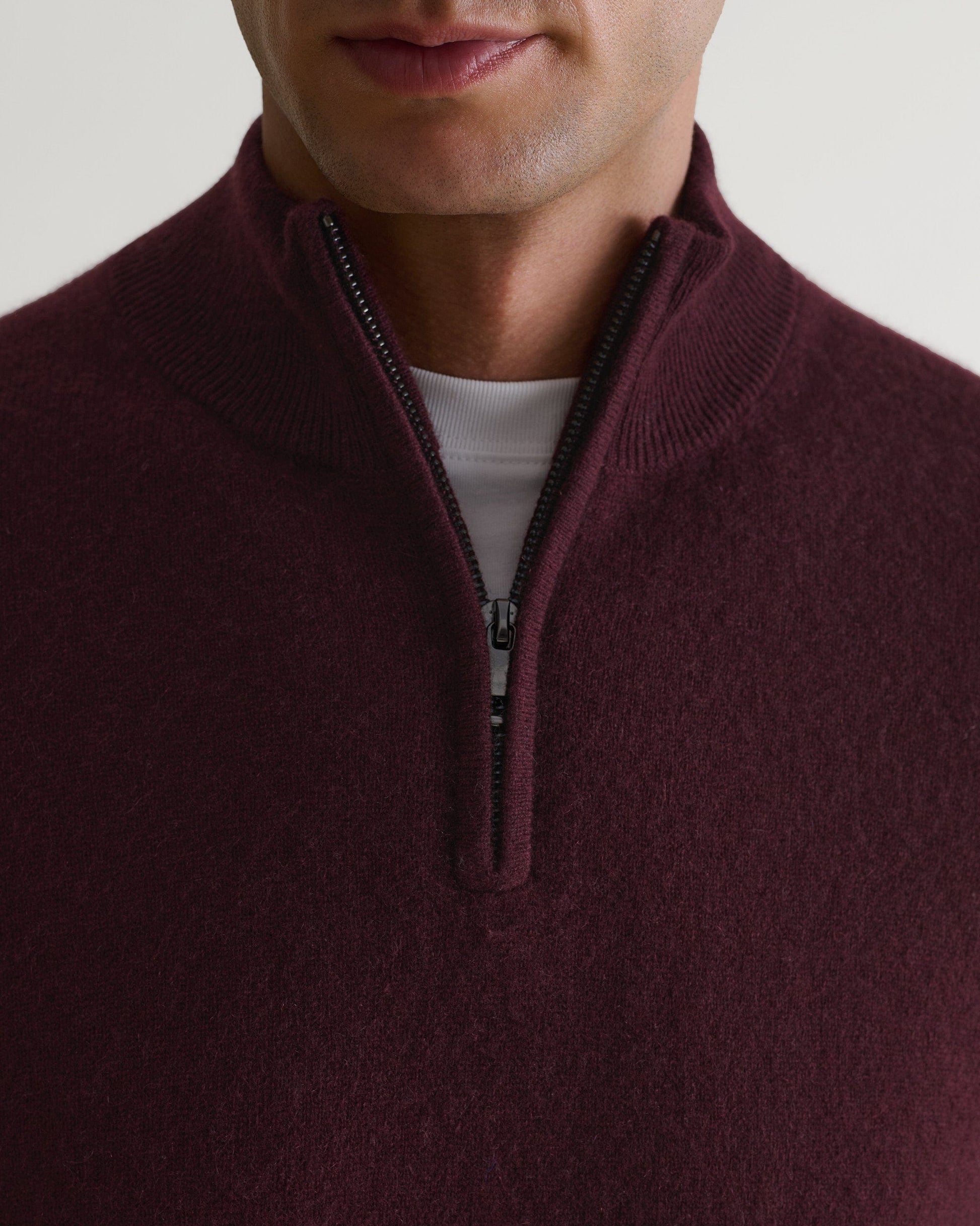 Image 3 of 6 showing man wearing Rise & Fall's fine cashmere 1/4 zip jumper, oxblood, close up.