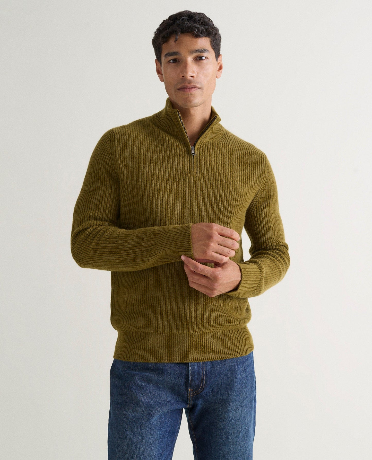 Image 3 of 6 showing man wearing Rise & Fall's Cashmere Merino Fishermans Rib 1/4 Zip Jumper in olive green.