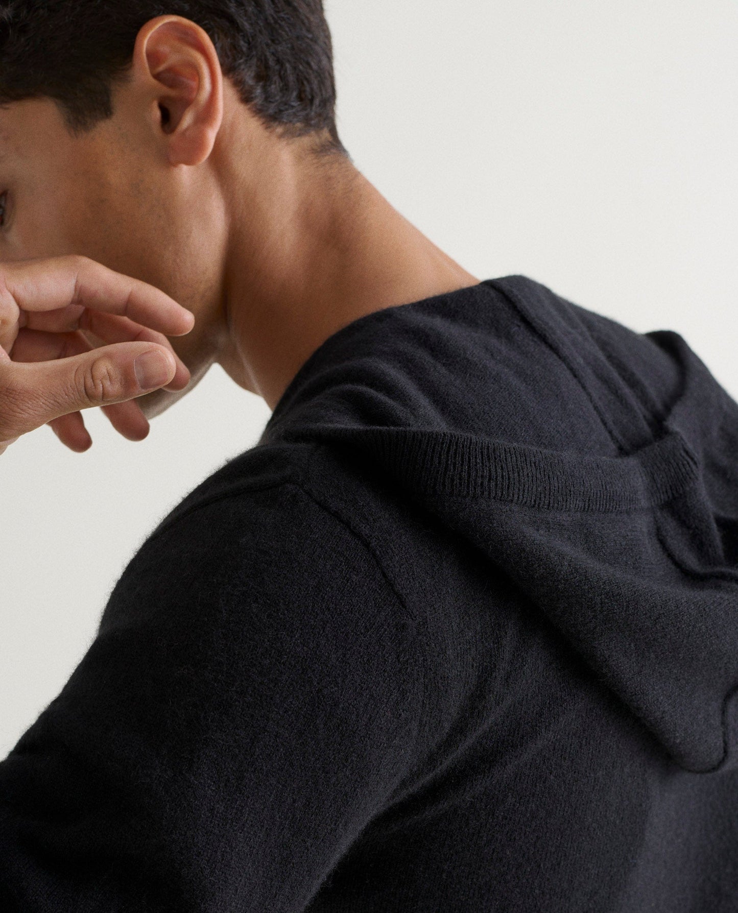 Image 4 of 4 showing man wearing Rise & Fall's fine cashmere zip hoodie, black.