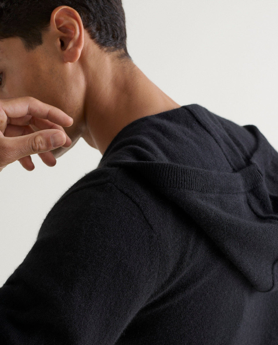 Image 4 of 4 showing man wearing Rise & Fall's fine cashmere zip hoodie, black.