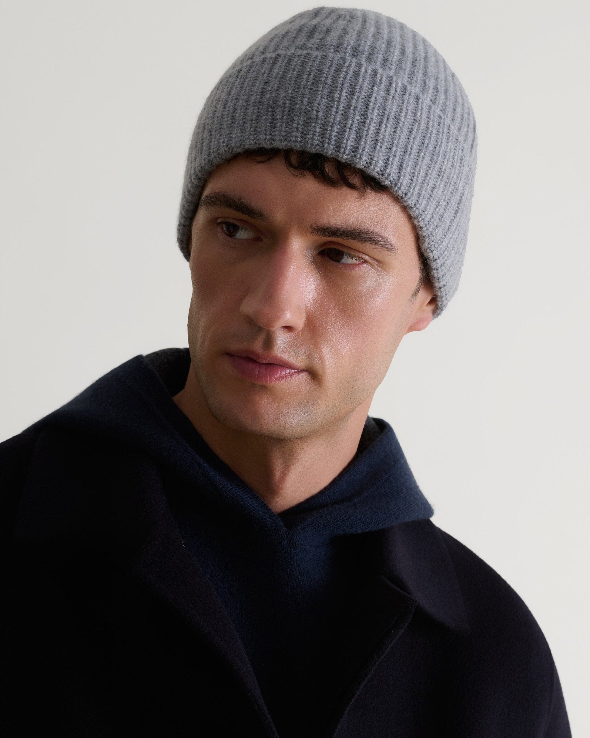 Image 4 of 4 showing man wearing Rise & Fall's Cashmere Merino Ribbed Knit Beanie in grey.