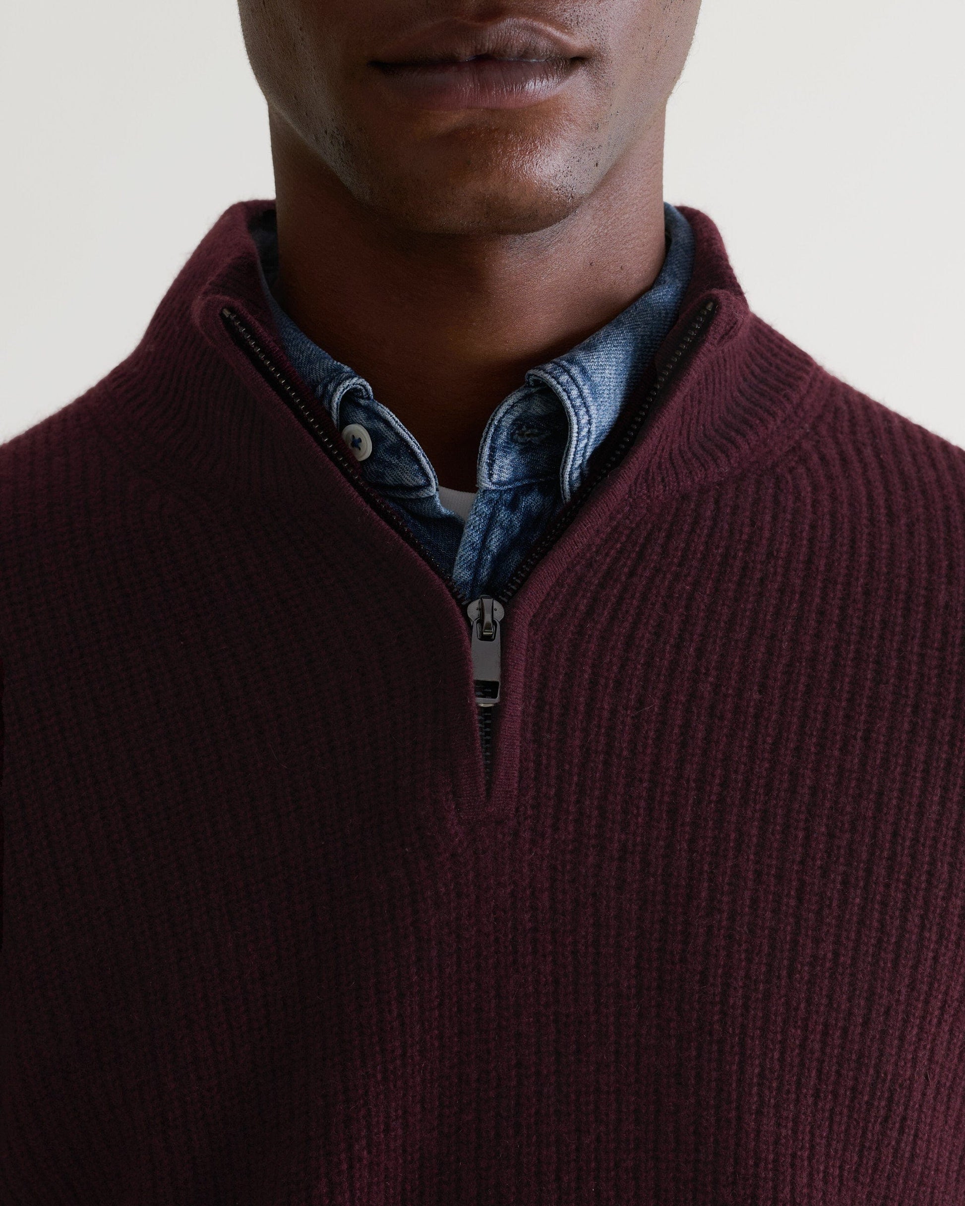 Image 4 of 4 showing close up of man wearing Rise & Fall's Cashmere Merino Fishermans Rib 1/4 Zip Jumper in oxblood.