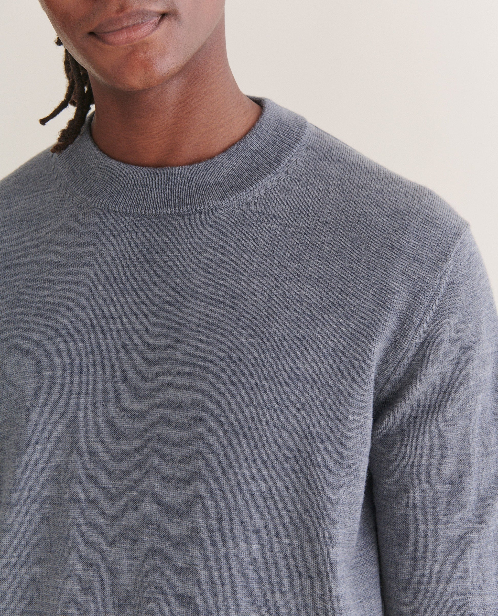 Image 4 of 4 showing close up of man wearing Rise & Fall's merino mid-weight crew neck jumper in grey.