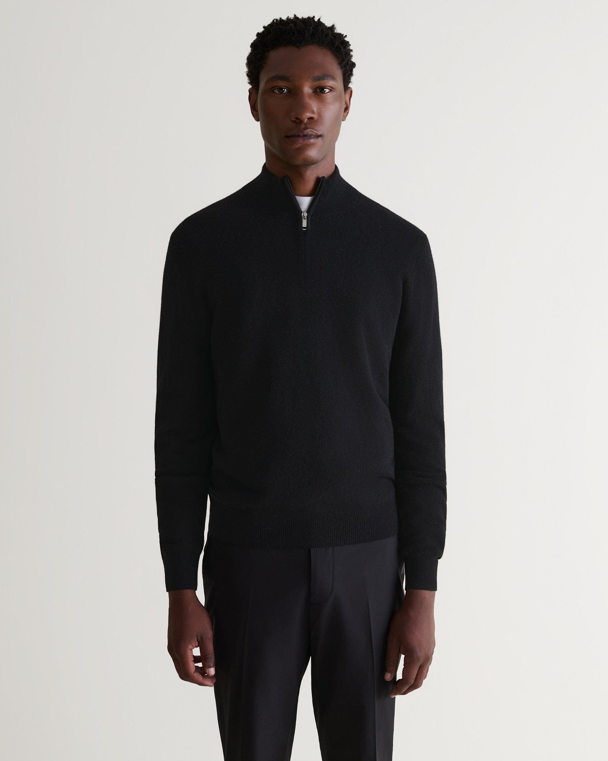 Image 4 of 5 showing man wearing Rise & Fall's fine cashmere 1/4 zip jumper, black.