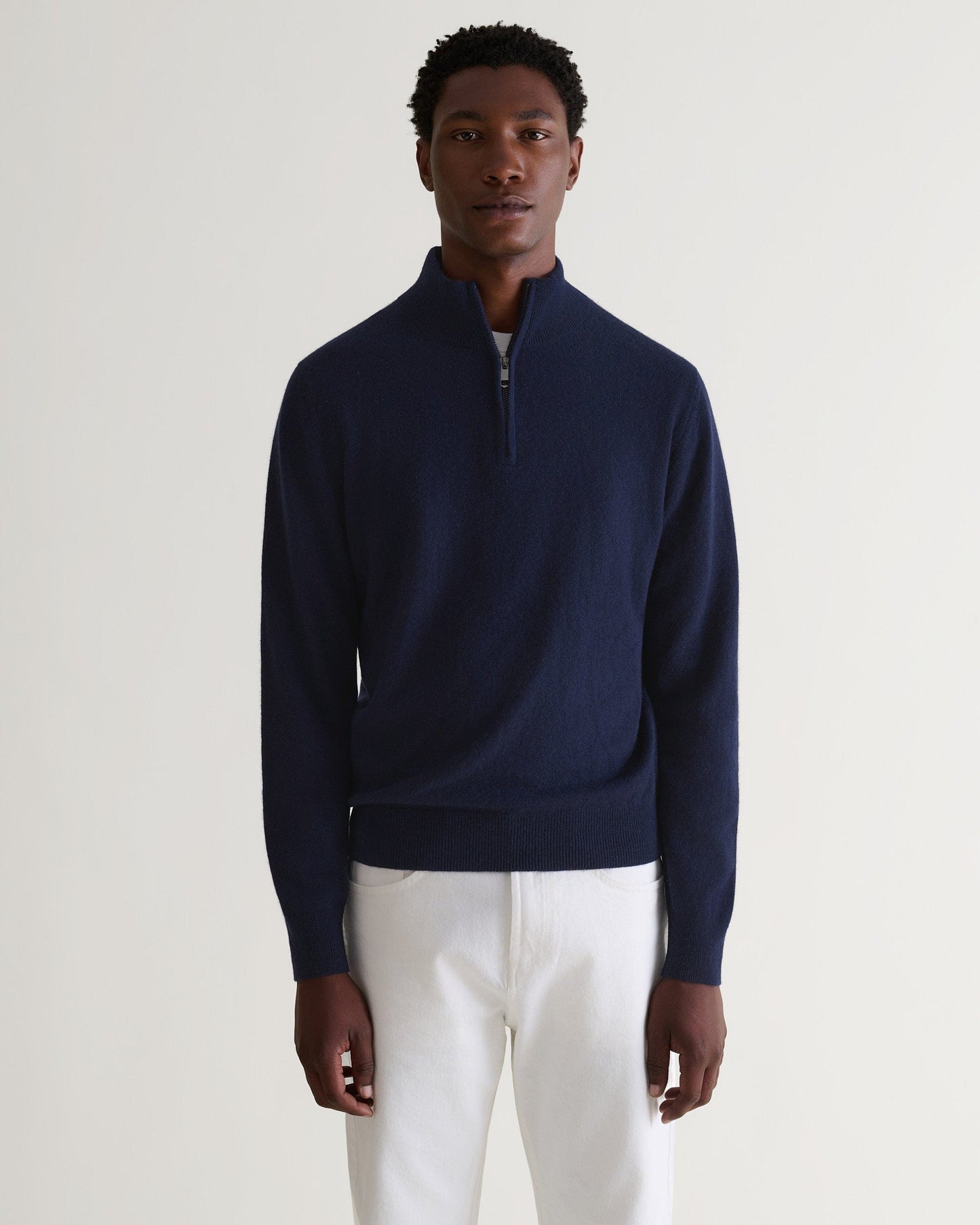 Image 4 of 5 showing man wearing Rise & Fall's fine cashmere 1/4 zip jumper, navy.