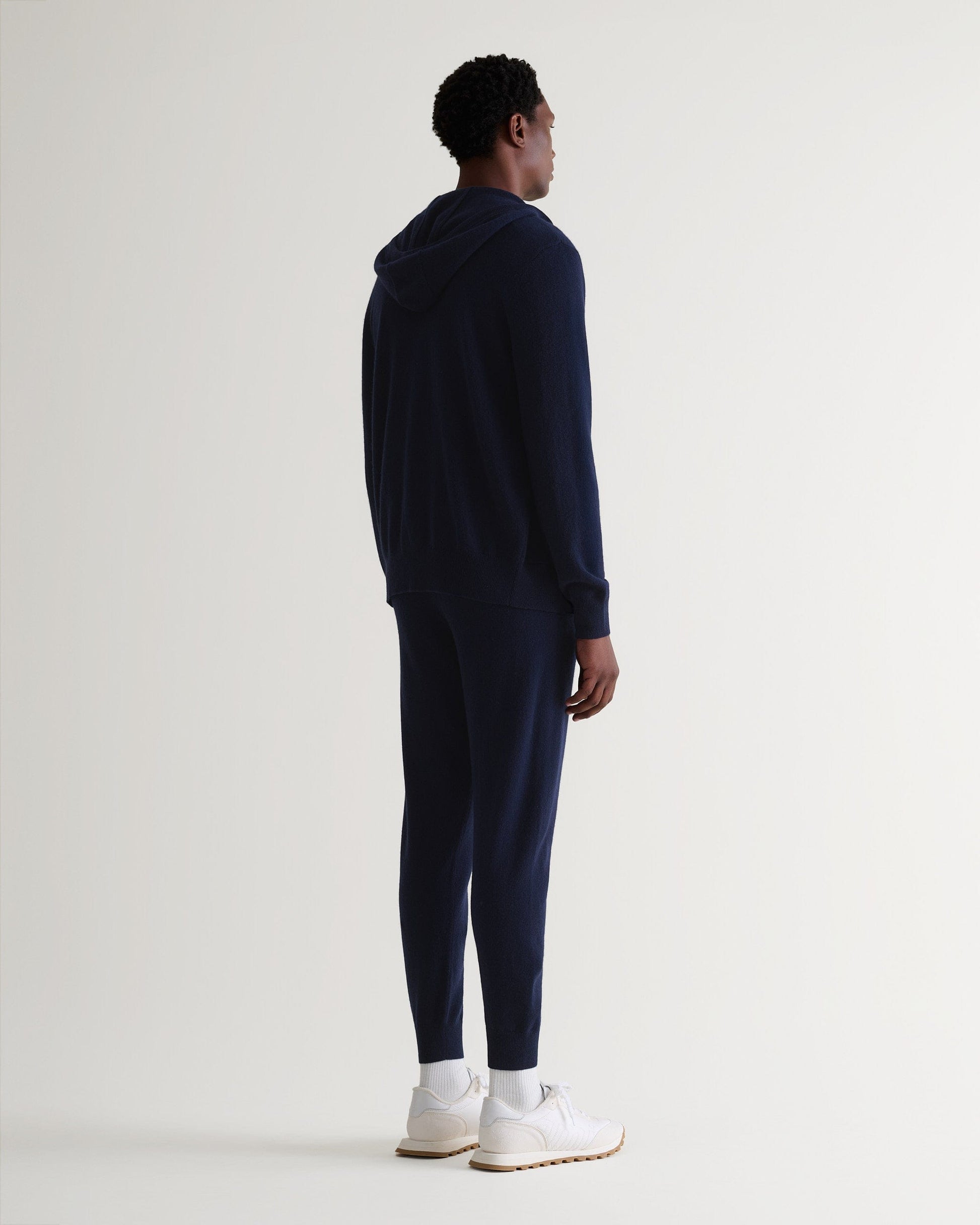 Image 4 of 5 showing man wearing Rise & Fall's fine cashmere zip hoodie, navy, back view.