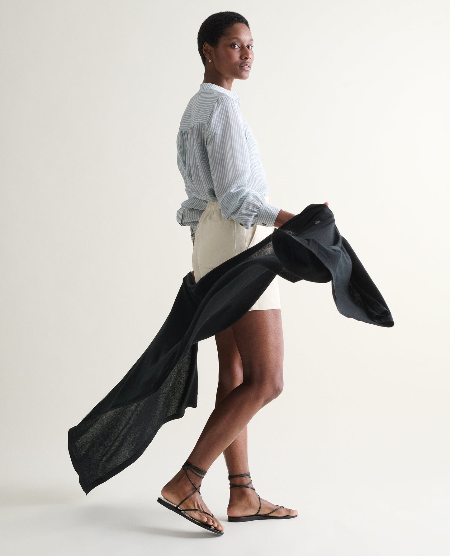 Image 4 of 5 showing woman holding Rise & Fall's black oversized cashmere scarf.