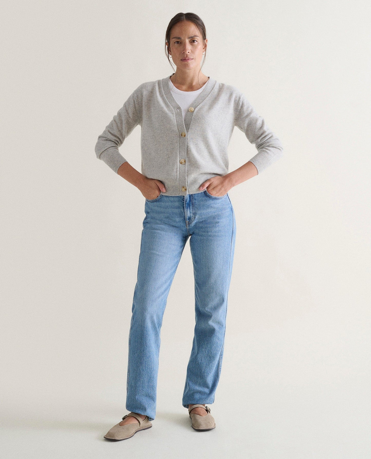 Image 4 of 5 showing woman wearing Rise & Fall's grey fine cashmere v-neck cardigan.