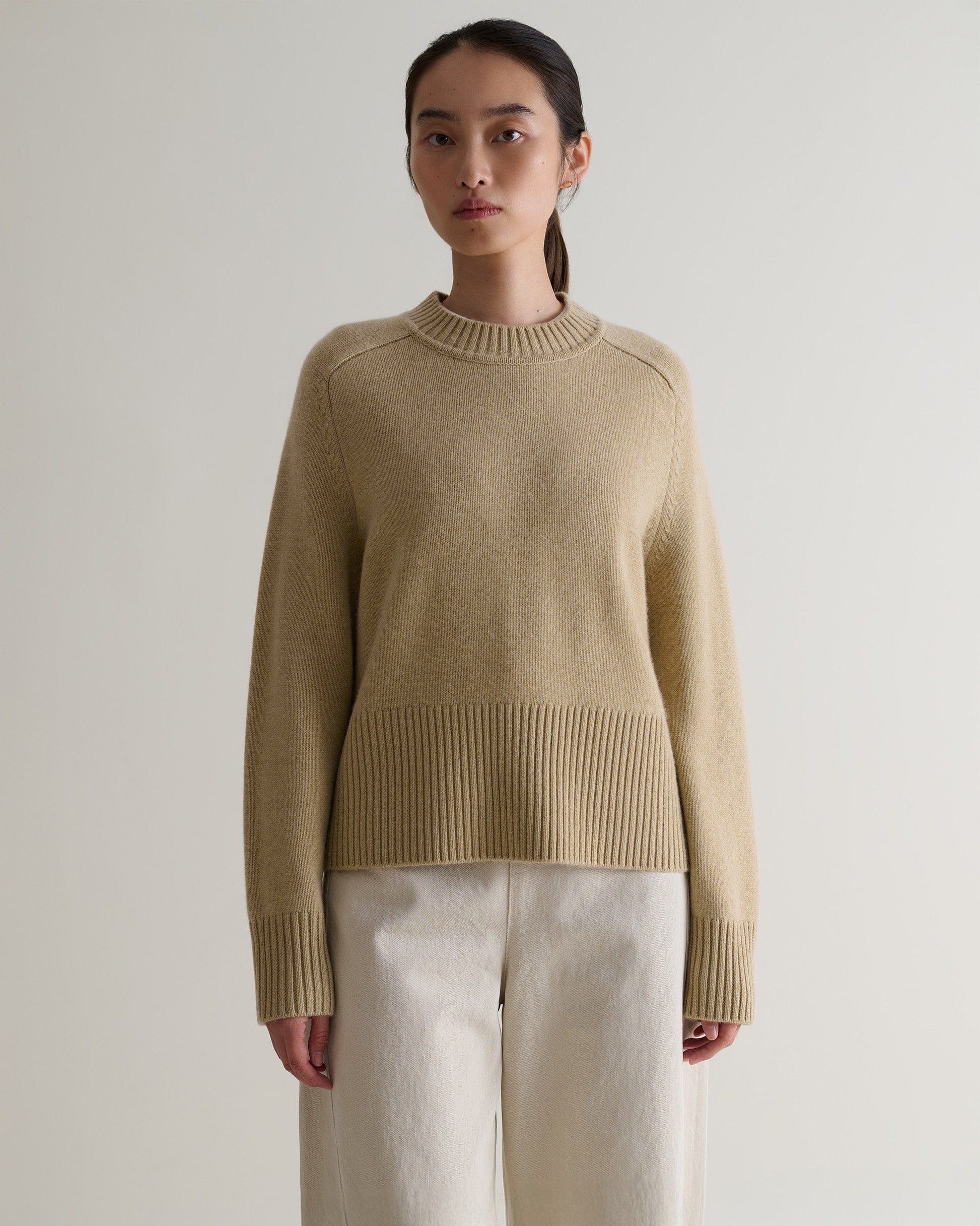 Image 4 of 5 showing woman wearing Rise & Fall twine cashmere merino saddle sleeve crew neck with cream jeans.