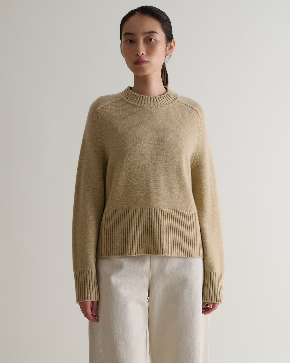 Image 4 of 5 showing woman wearing Rise & Fall twine cashmere merino saddle sleeve crew neck with cream jeans.