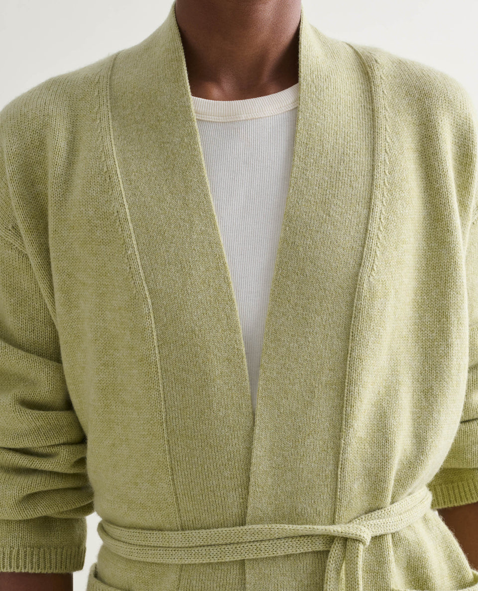 Image 4 of 5 showing close up of woman wearing Rise & Fall's lichen green cashmere merino belted cardigan with white t-shirt.
