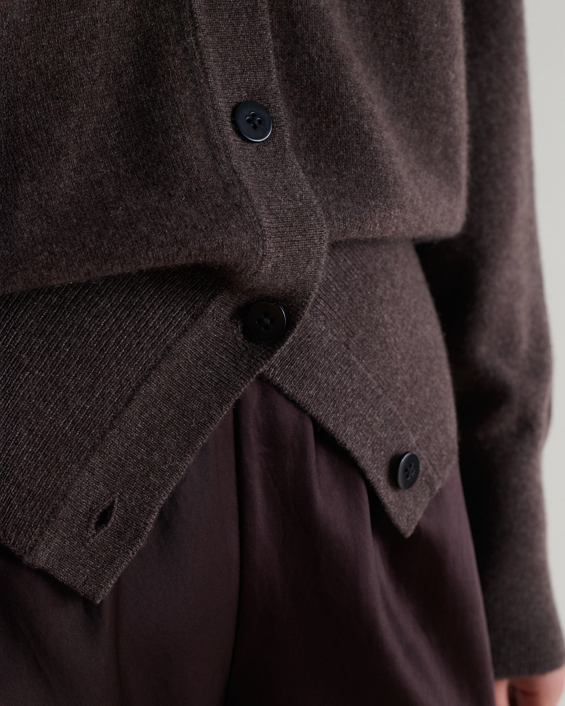 Image 4 of 6 showing close up Rise & Fall's chocolate fine cashmere blouson cardigan with silk brown trousers.