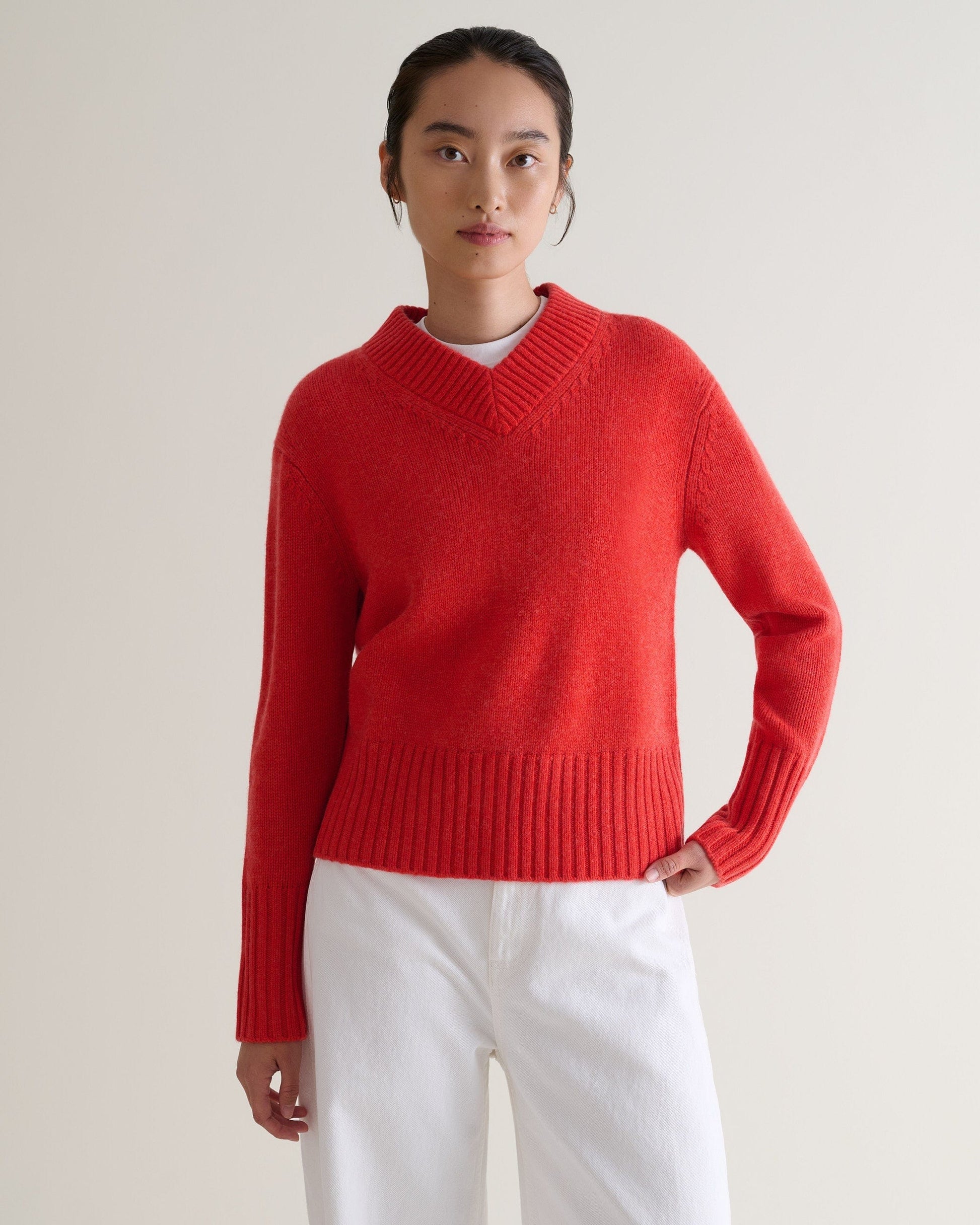 Image 4 of 6 showing woman wearing Rise & Fall poppy red cashmere merino saddle sleeve crew neck jumper with wite t-shirt and white jeans.