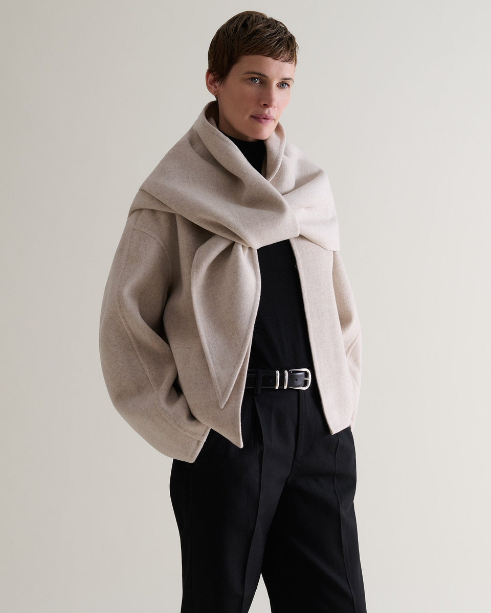 Image 4 of 9 showing woman wearing Rise & Fall's twine cashmere wool double faced scarf jacket with black trousers and top.