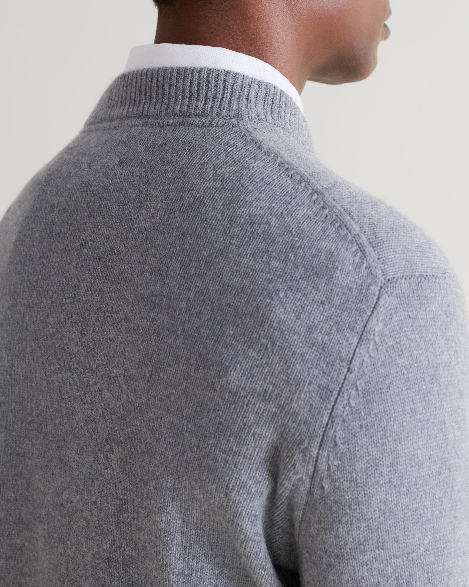 Image 5 of 5 showing close up of man wearing Rise & Fall's finest cashmere mid-weight crew neck jumper in grey with white shirt, back view.