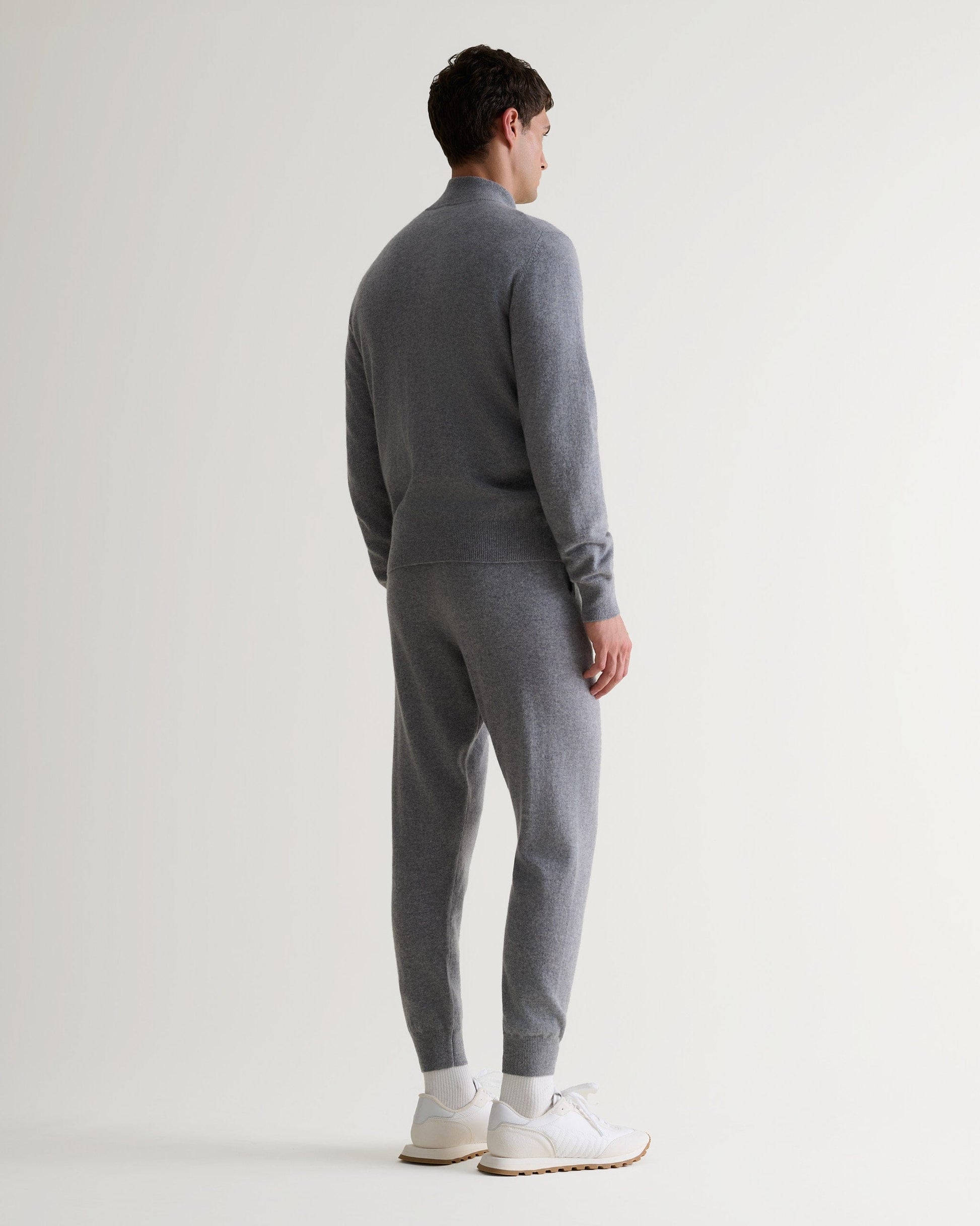 Image 5 of 5 showing man wearing Rise & Fall's fine cashmere 1/4 zip jumper, grey, back view.