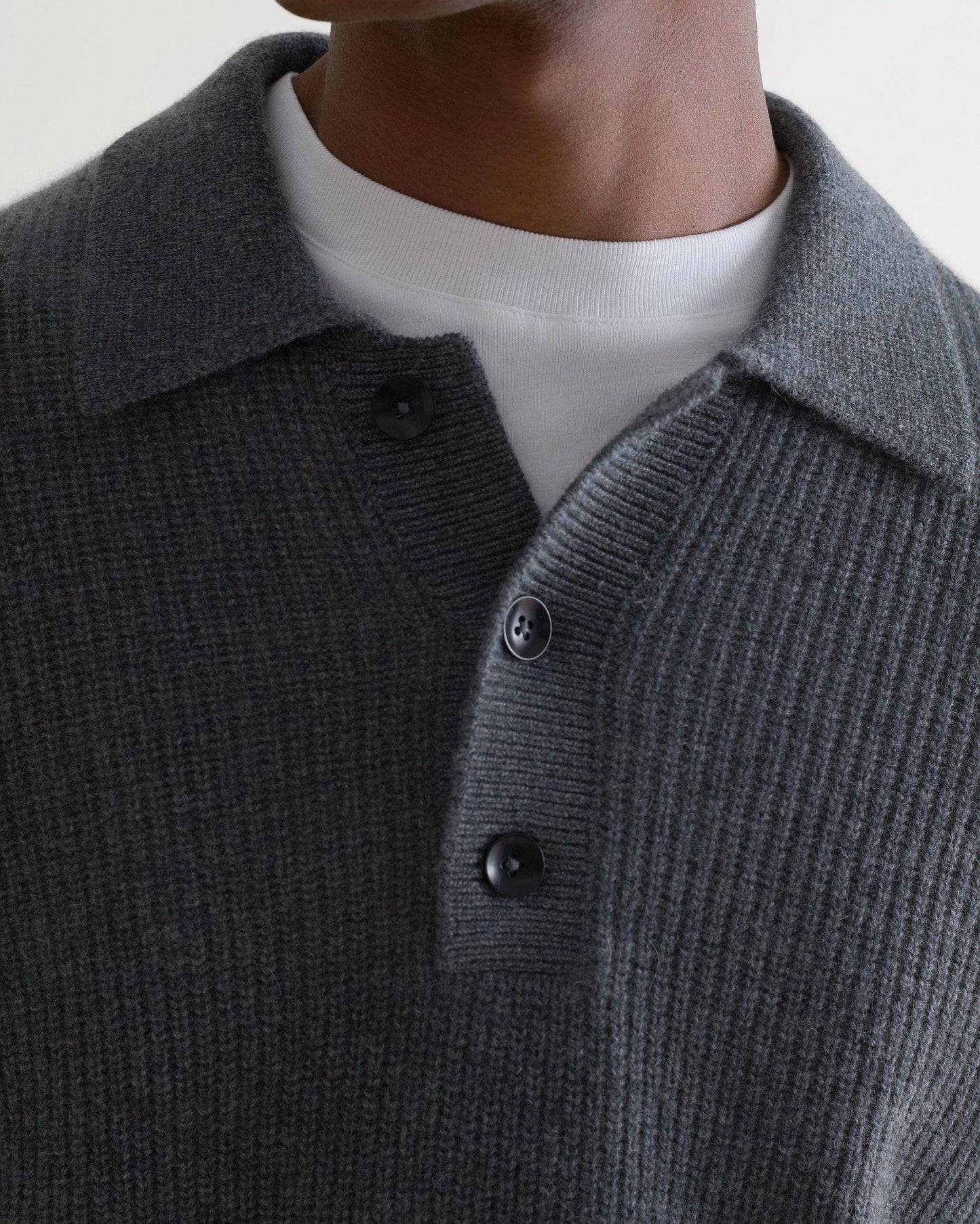 Image 5 of 5 showing man wearing Rise & Fall's graphite cashmere merino fisherman ribbed polo jumper with white T-Shirt