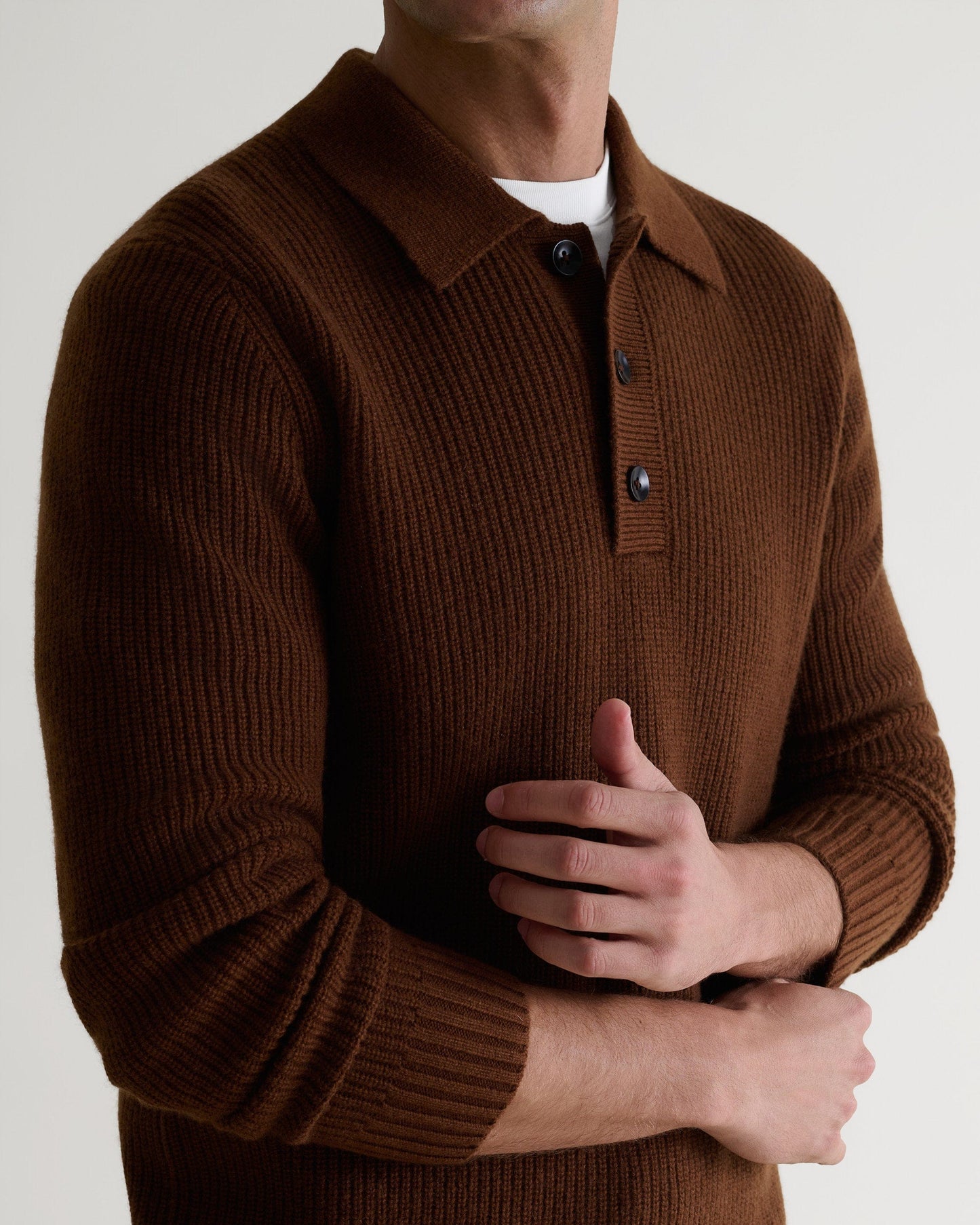 Image 5 of 6 shpwing man wearing Rise & Fall's brown cashmere merino ribbed fisherman buttoned polo with white crew neck T-shirt.