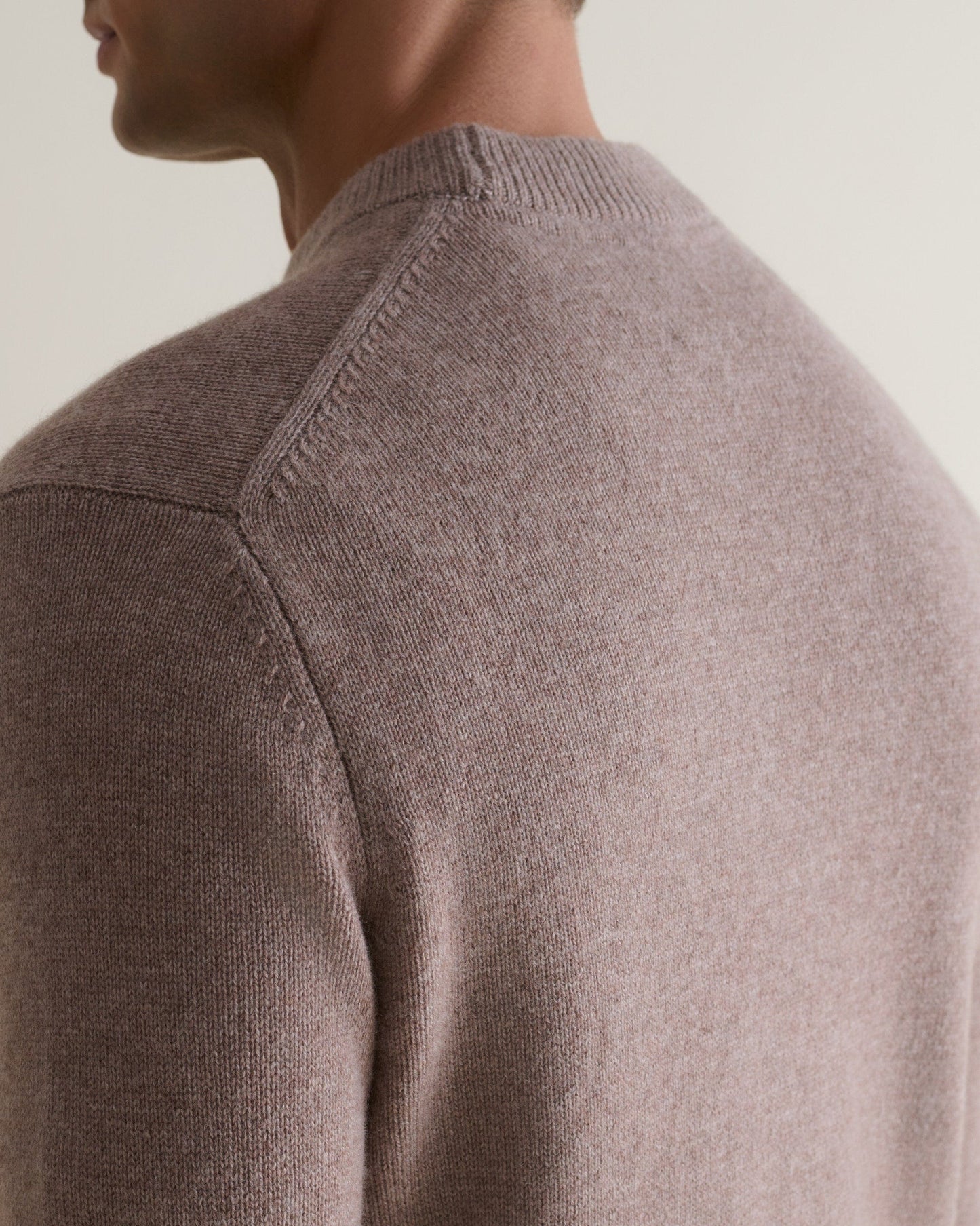 Image 5 of 6 showing close up of man wearing Rise & Fall's Finest Cashmere Mid-Weight Crew Neck Jumper in toast brown.
