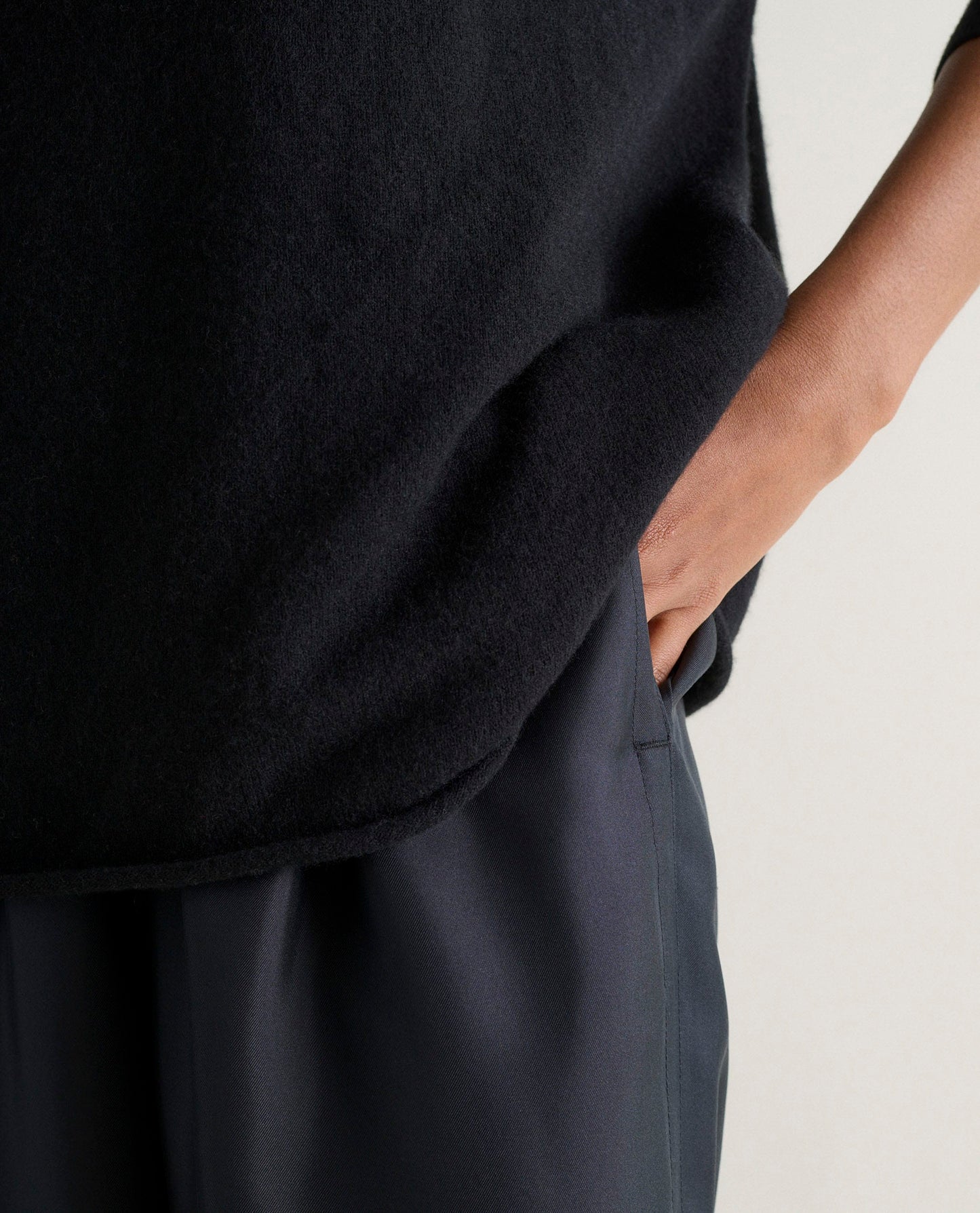 Image 5 of 6 showing a close up of Rise & Fall's black fine cashmere sweatshirt with black silk trousers.
