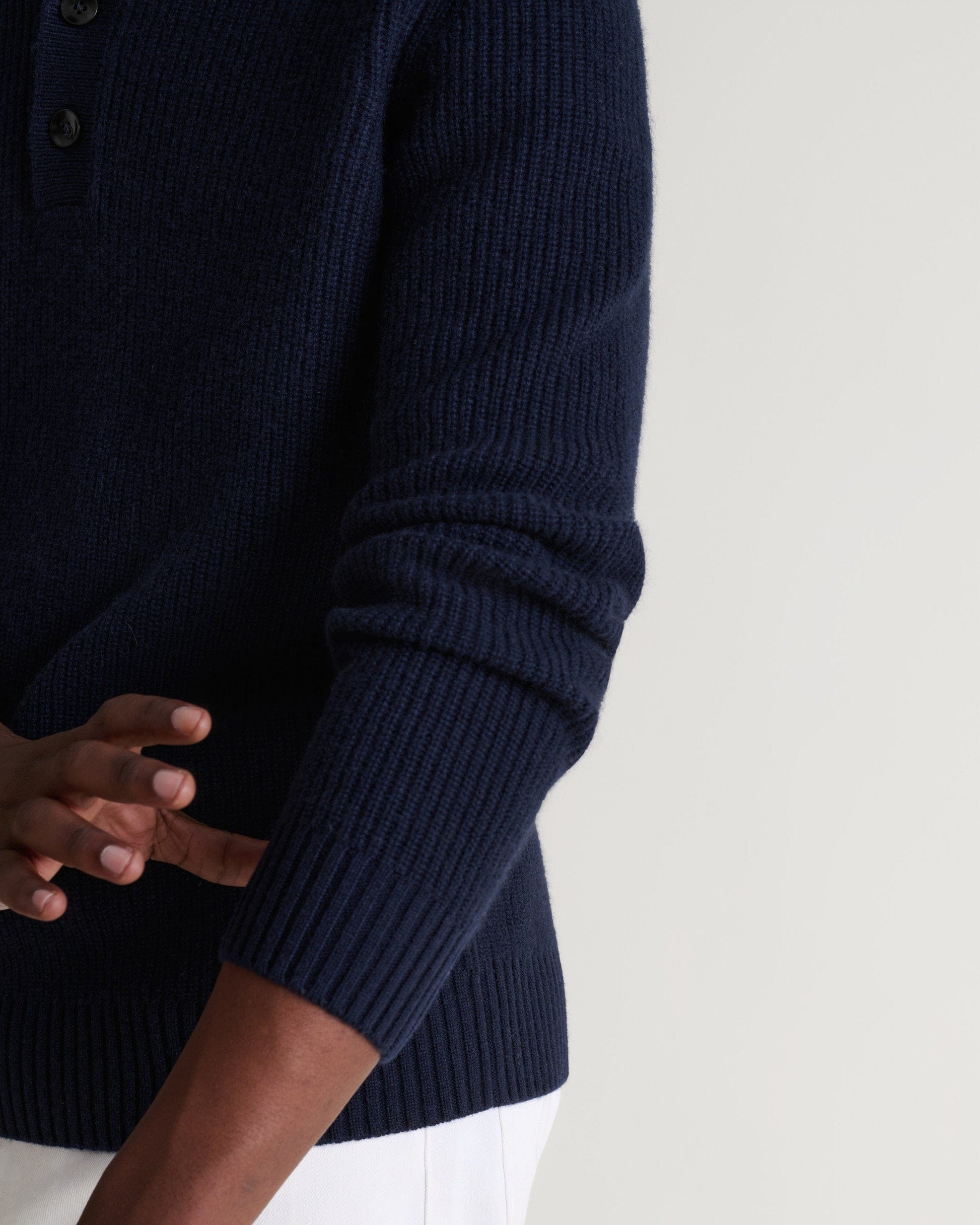 Image 6 of 6 showing man wearing Rise & Fall's indigio blue cashmere merino fisherman ribbed polo sweater. Close up of sleeve.