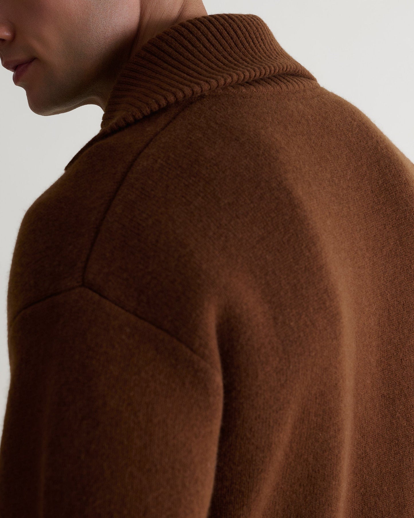 Image 6 of 6 showing close up of man wearing burl brown cashmere merino buttoned knitted bomber. Close up of shoulder and neck.