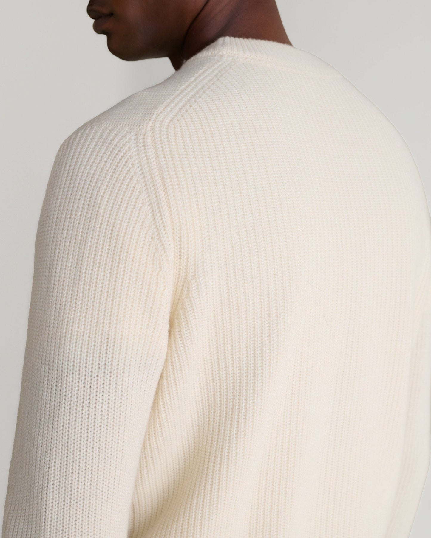 Image 6 of 6 showing close up of man wearing Rise & Fall's Cashmere Merino Fishermans Rib 1/4 Zip Jumper in cream.