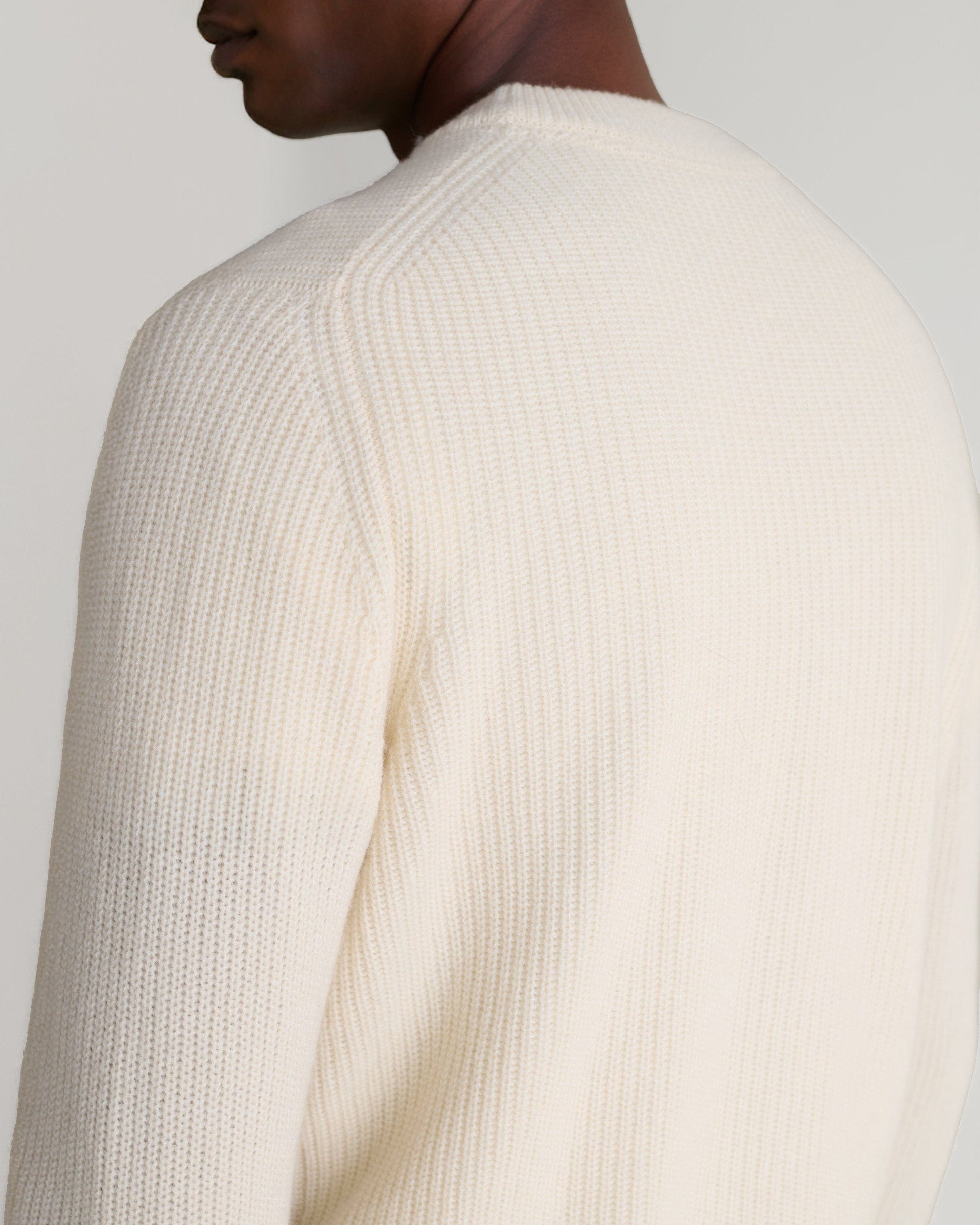 Image 6 of 6 showing close up of man wearing Rise & Fall's Cashmere Merino Fishermans Rib 1/4 Zip Jumper in cream.