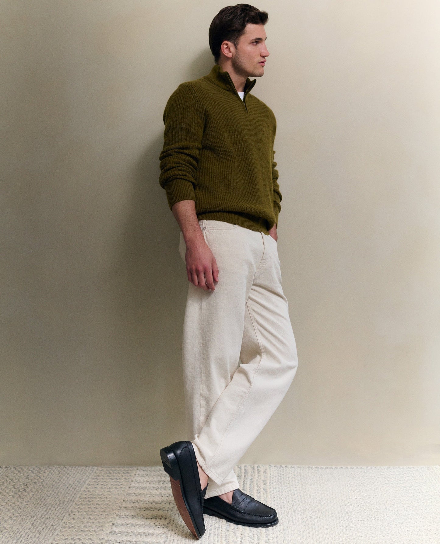 Image 6 of 6 showing man wearing Rise & Fall's Cashmere Merino Fishermans Rib 1/4 Zip Jumper in olive green.