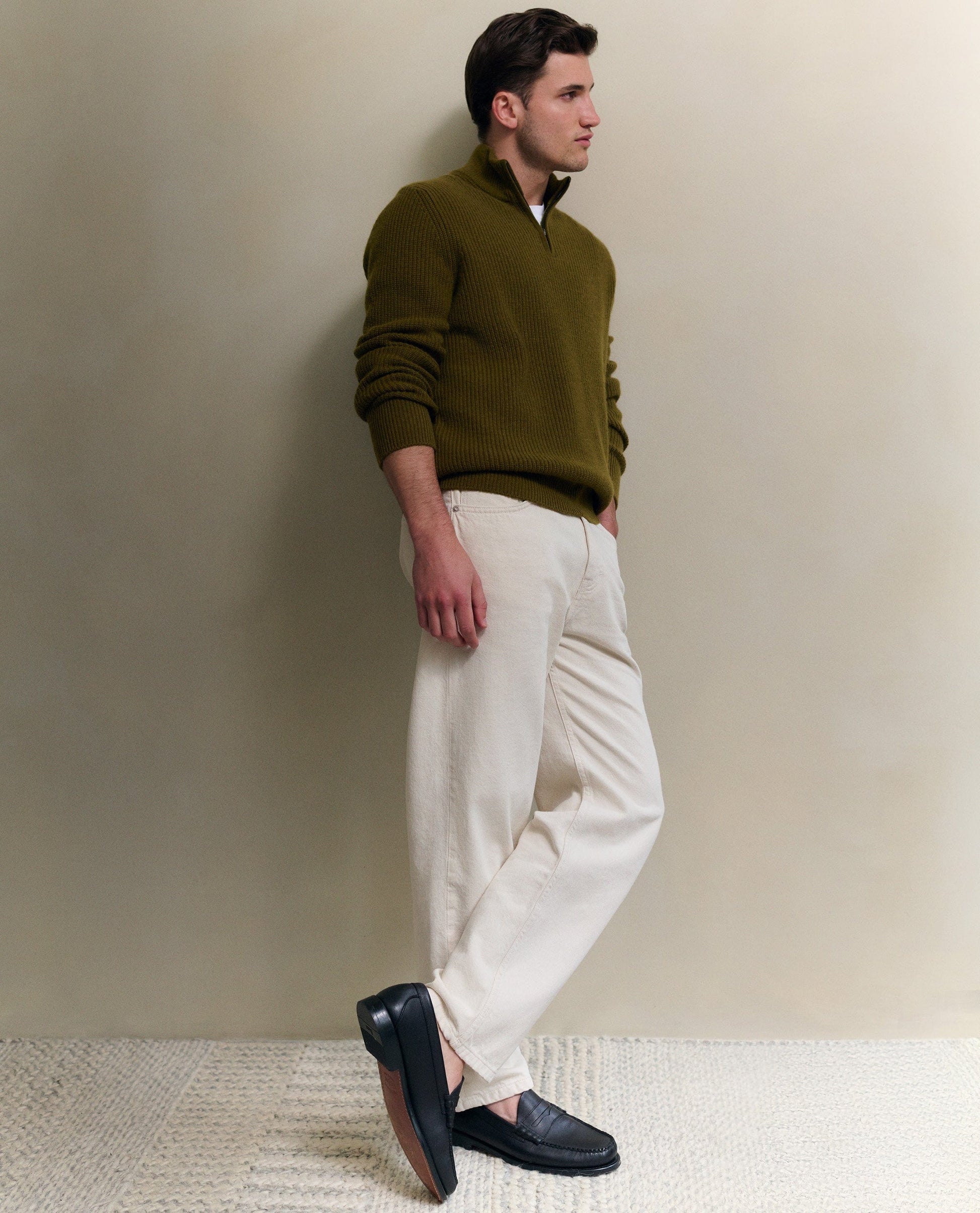 Image 6 of 6 showing man wearing Rise & Fall's Cashmere Merino Fishermans Rib 1/4 Zip Jumper in olive green.