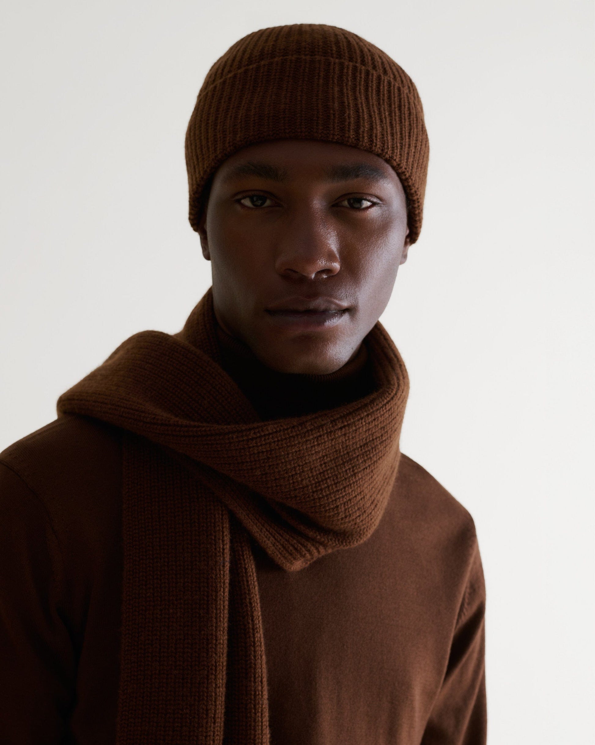 Close up of man wearing burl brown cashmere merino ribbed beanie with matching coloured scarf and jumper