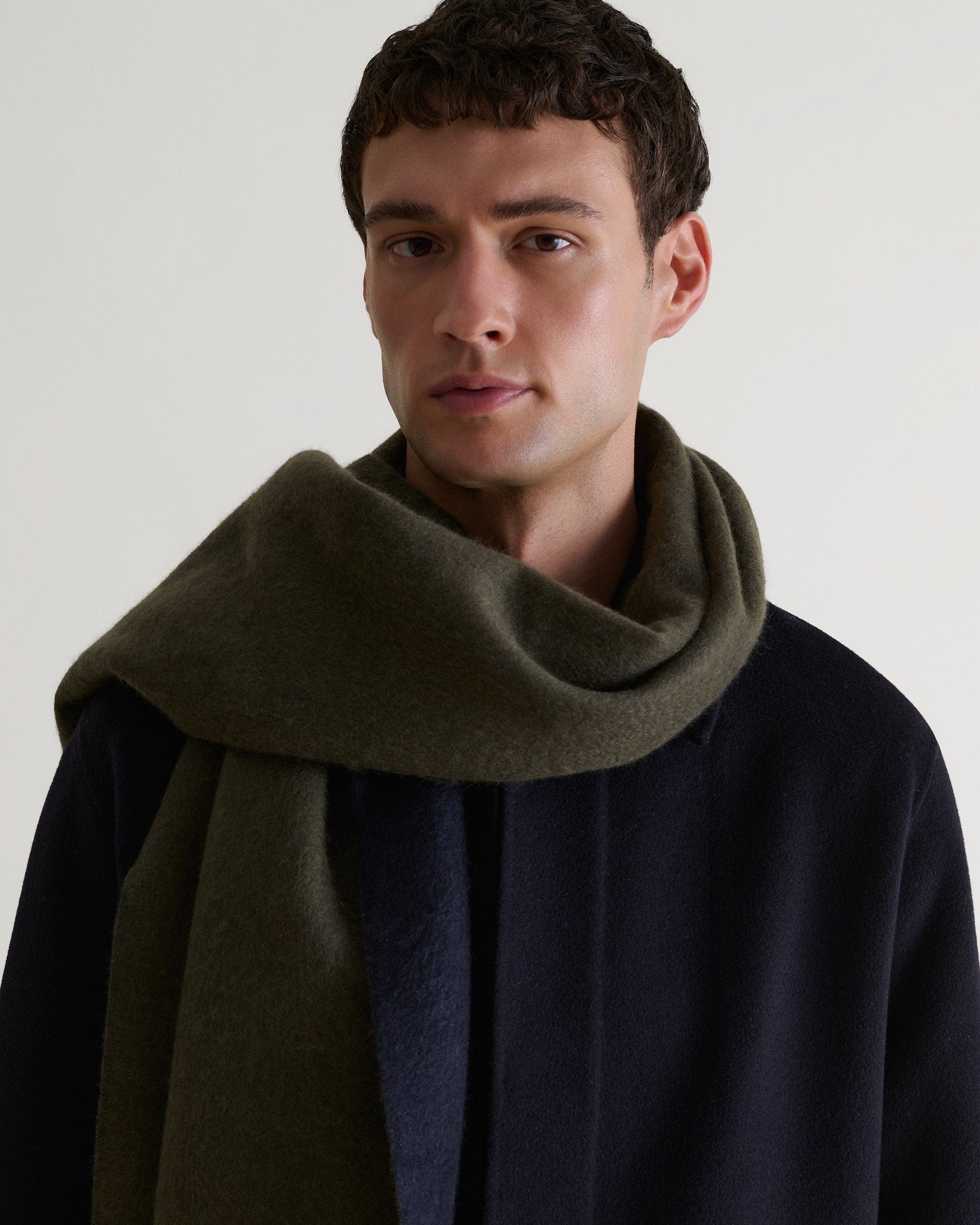 Man wearing Rise & Fall's finest cashmere double faced scarf - navy and olive
