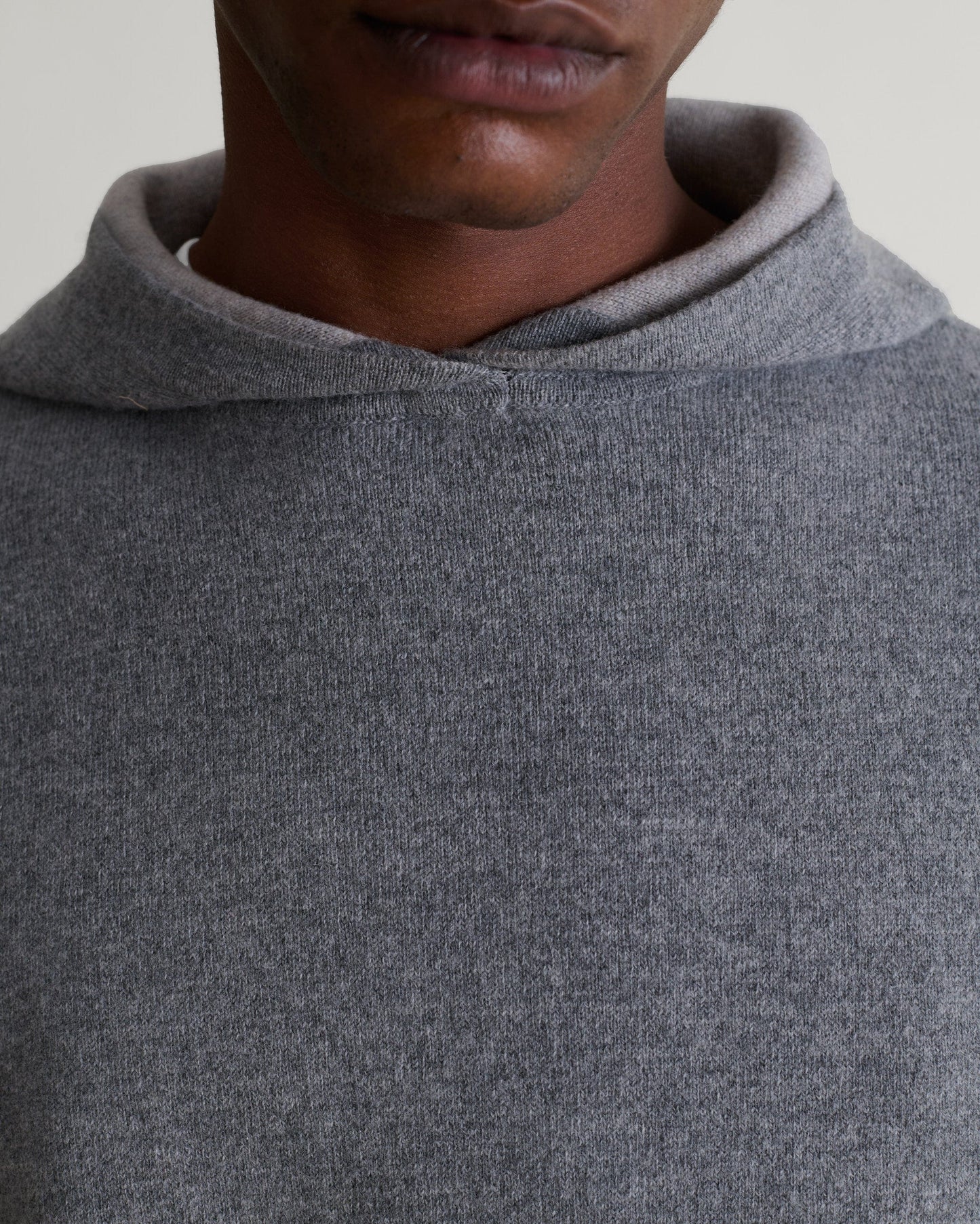 Close up front of man wearing Rise & Fall's grey cashmere merino double-faced hoodie.