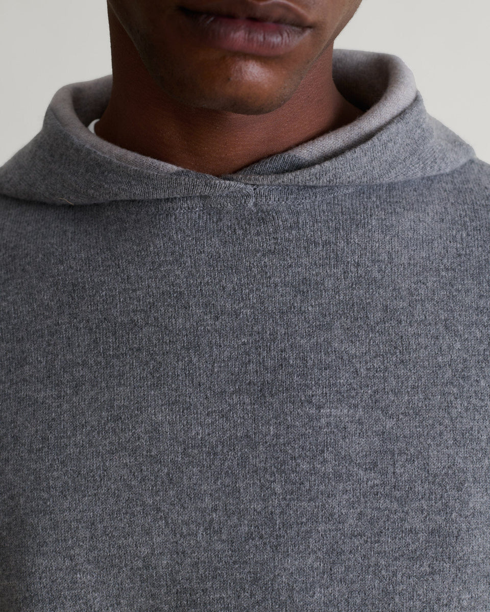 Close up front of man wearing Rise & Fall's grey cashmere merino double-faced hoodie.