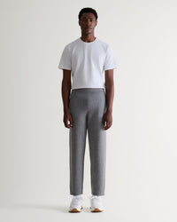 Front view of man wearing Rise & Fall's grey cashmere merino double-faced joggers with crew neck white T-shirt.