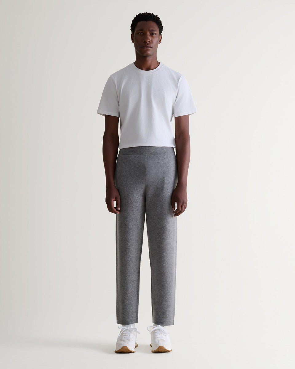 Front view of man wearing Rise & Fall's grey cashmere merino double-faced joggers with crew neck white T-shirt.