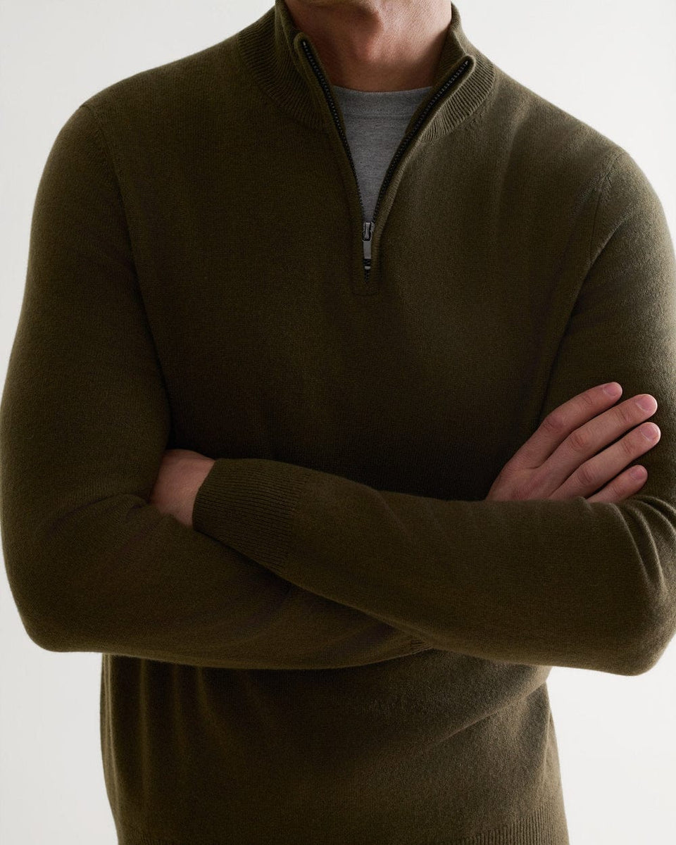 Close up of man wearing Rise & Fall's military green finest cashmere 1/4 zip jumper with a grey T-shirt.
