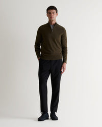 Full length front view of man wearing Rise & Fall's military green finest cashmere 1/4 zip jumper. Worn with black trousers.